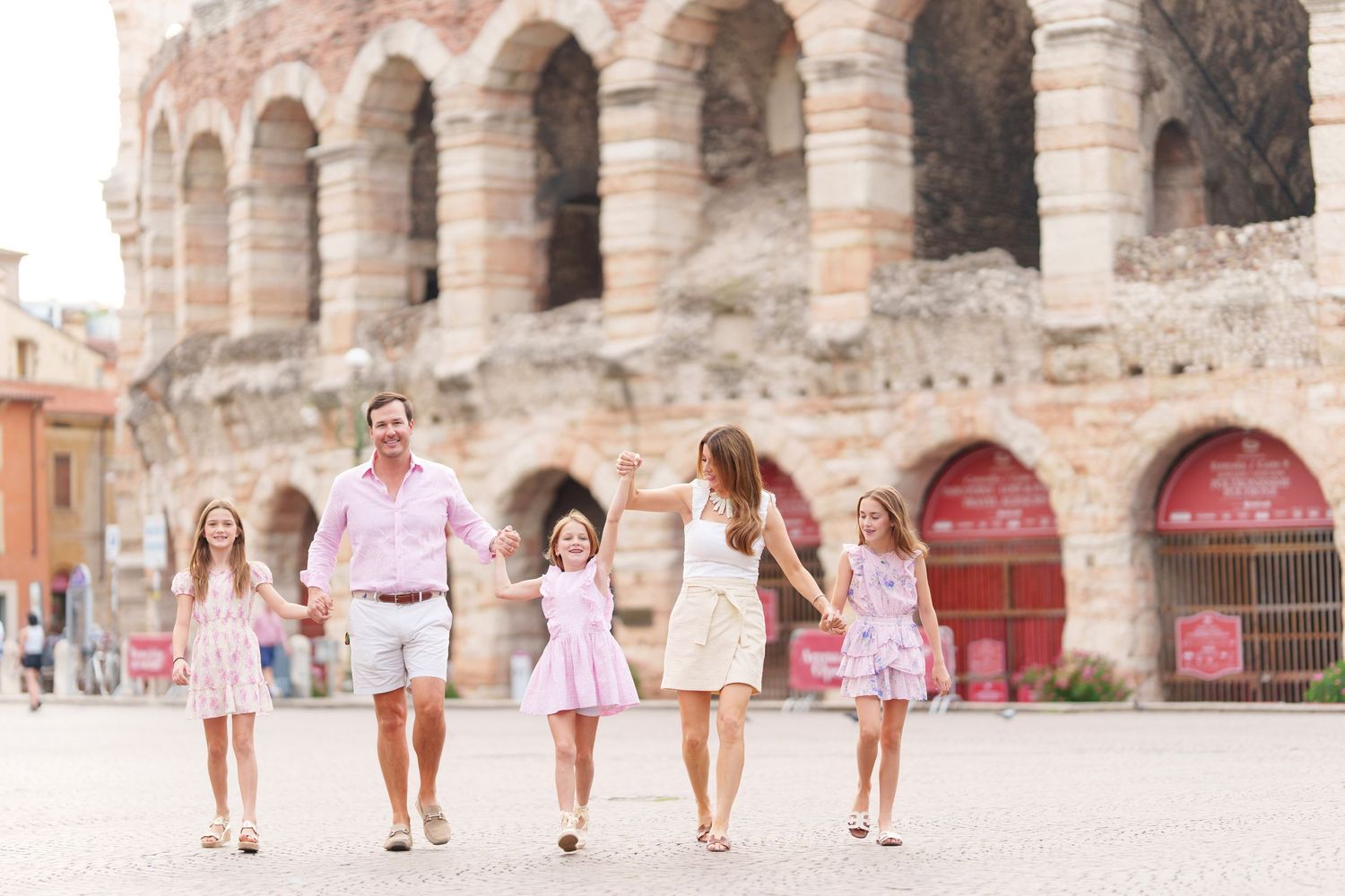 Verona family photographer family walking in front of Verona Arena Italy