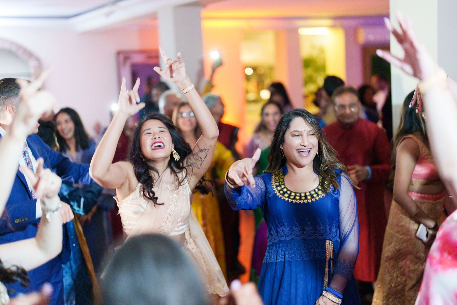 Energetic party scene with guests dancing in blue and colorful formal attire.