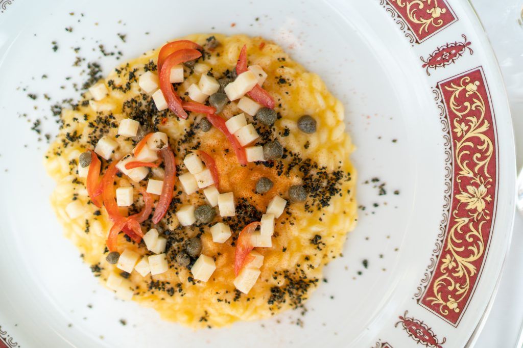Colorful seafood appetizer garnished with herbs on decorative china plate.
