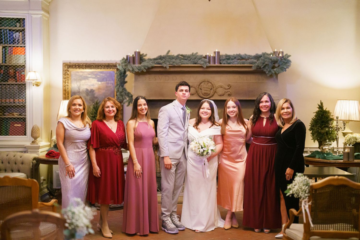 Wedding party members gather in formal attire at an elegant indoor venue.