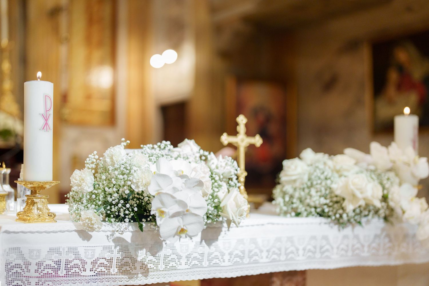 White altar decorations with crosses and floral arrangements for church wedding ceremony.