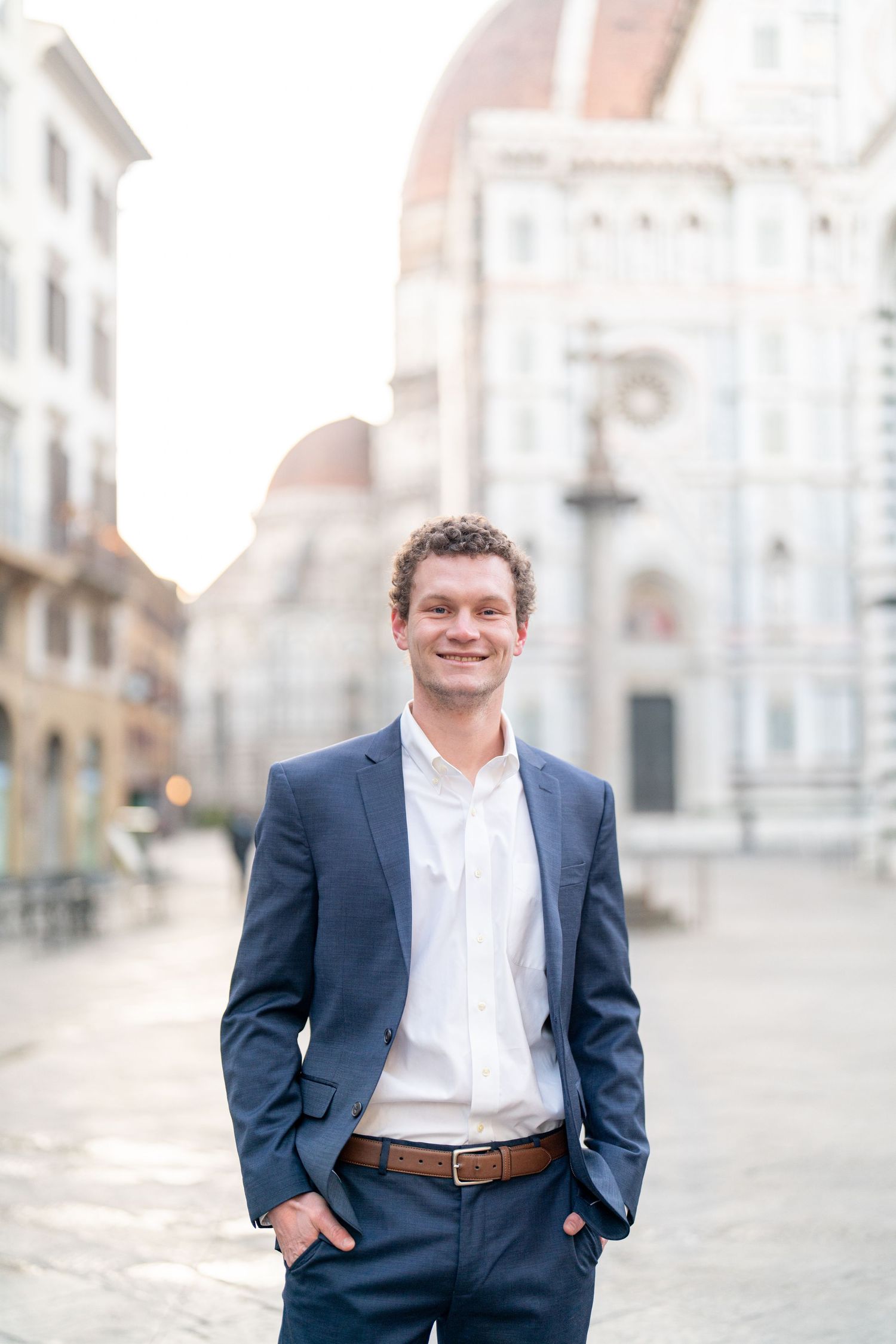 Professional portrait session in a European city square with architectural buildings in the background.
