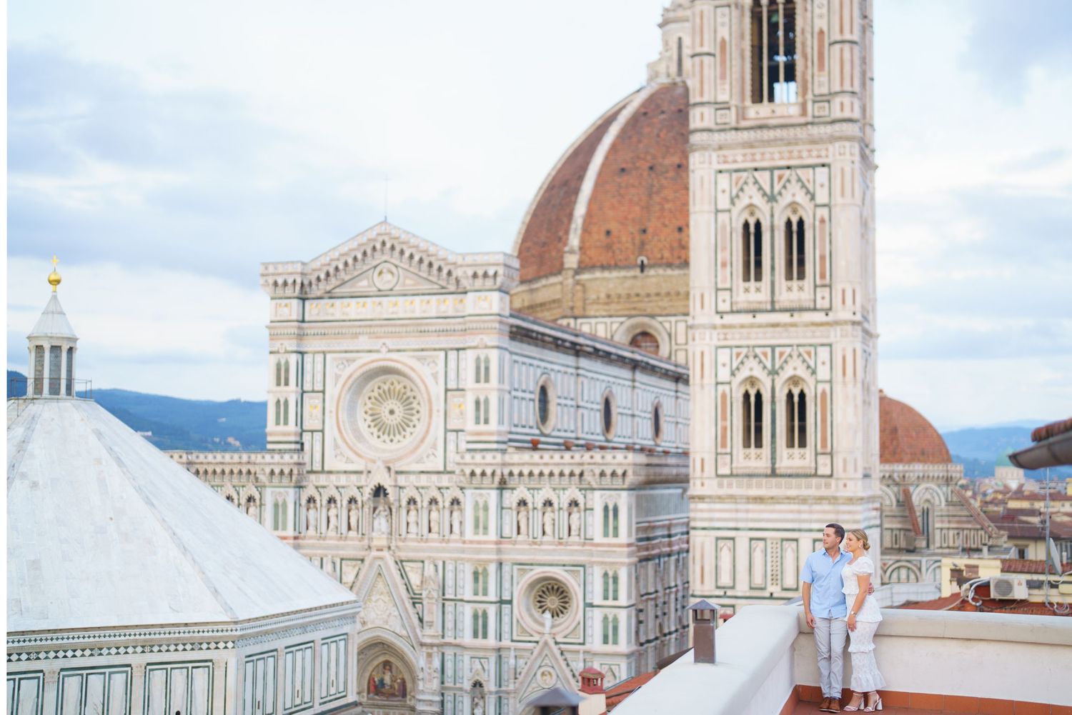 The historic Florence Cathedral and Giotto's Bell Tower stand majestically against a cloudy sky in Florence, Italy.