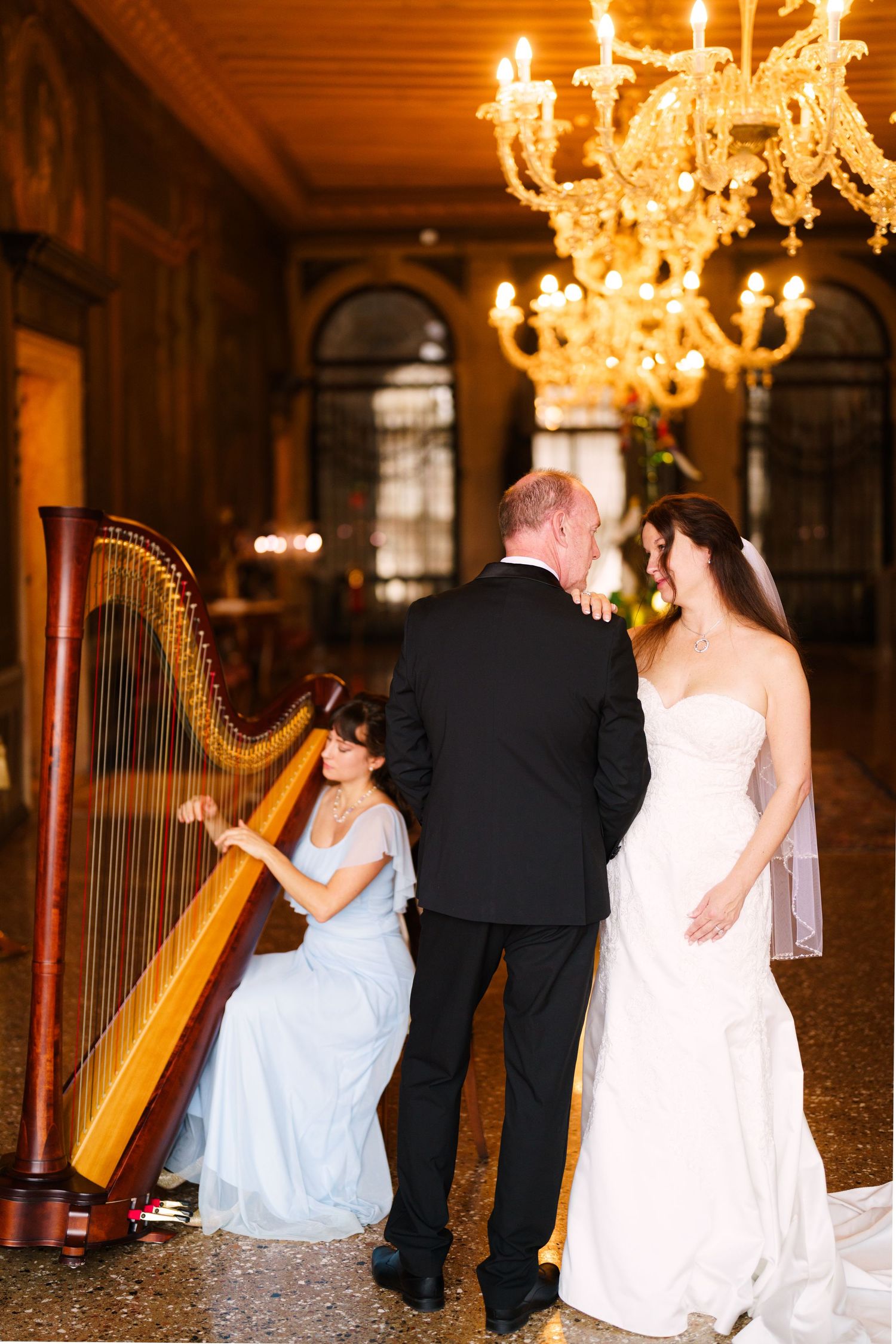 A series of romantic dance photos with a harp in an elegant ballroom setting illuminated by crystal chandeliers.