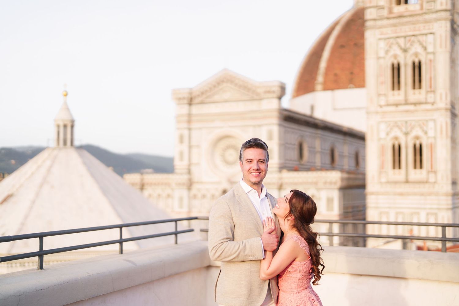A couple embraces in front of Florence Cathedral during a romantic sunset photoshoot in Italy.