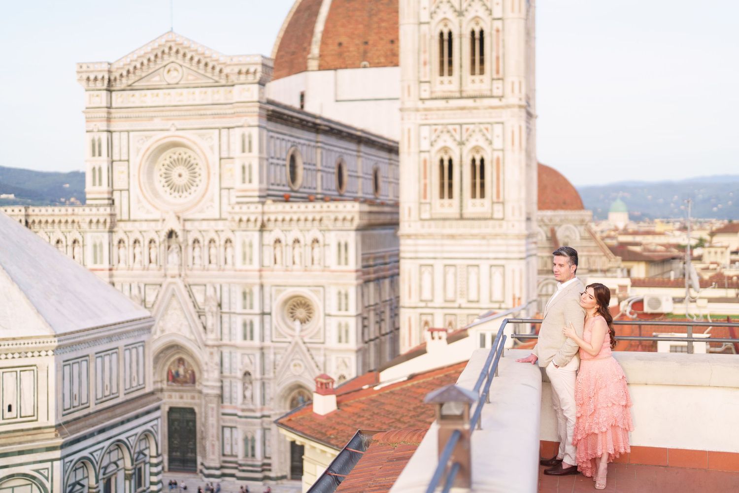 View of Florence Cathedral's iconic dome and architectural details against a sunny Italian sky.