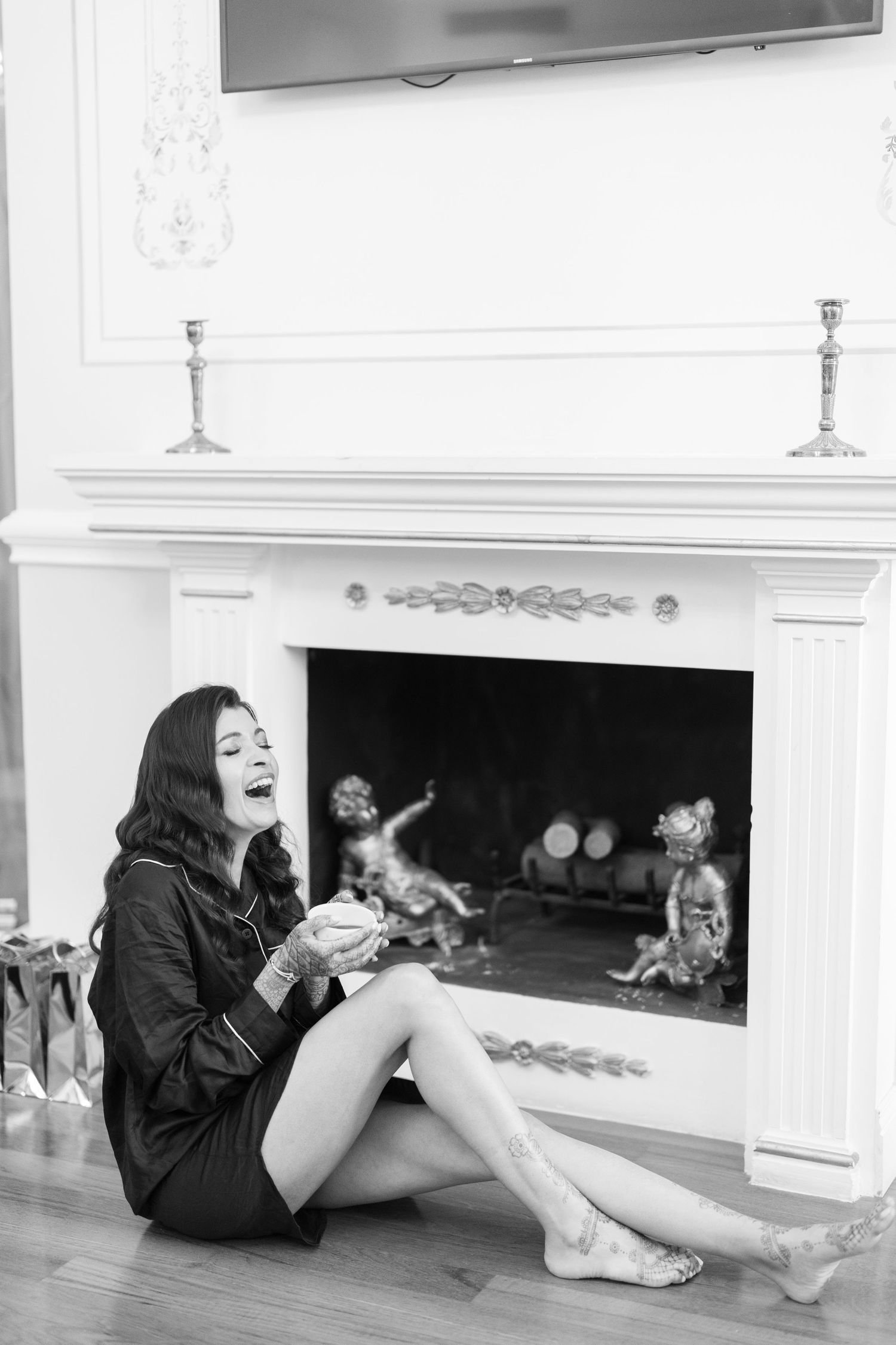 Black and white photos show playful poses by a fireplace in casual attire.