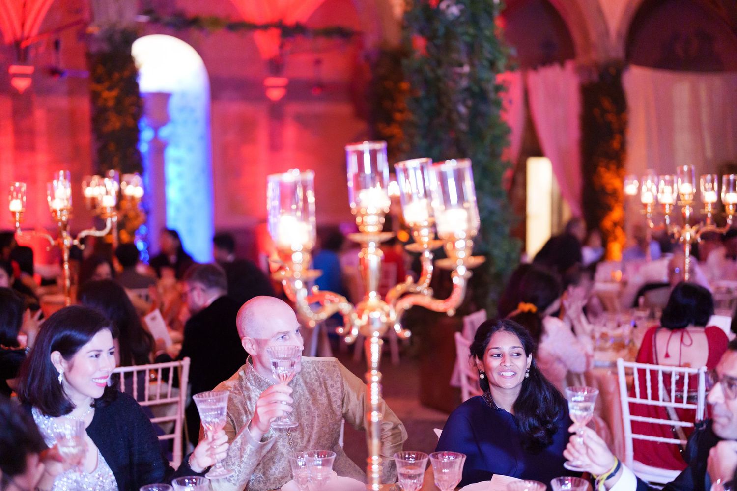 Wedding celebration venue illuminated with vibrant red and blue mood lighting.