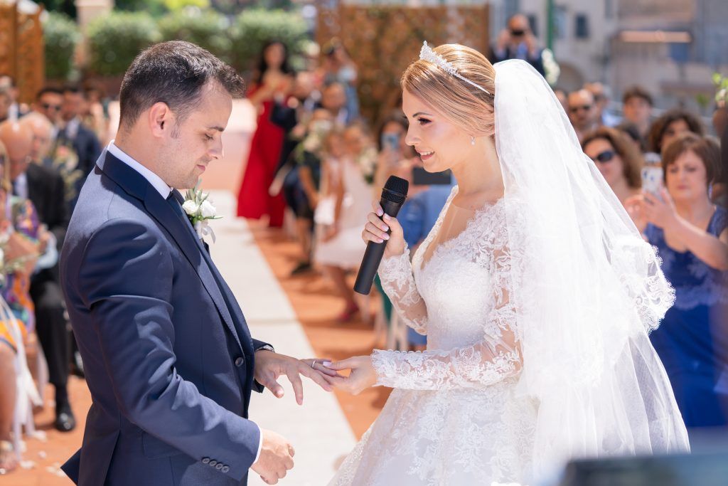 Joyful moments from an outdoor wedding ceremony with guests looking on.