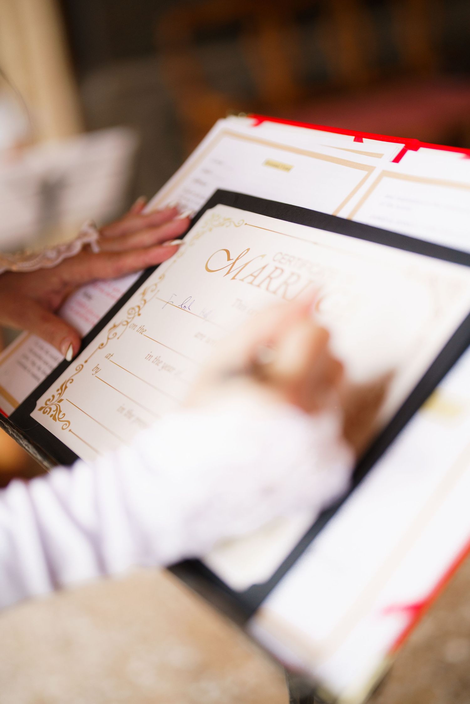 A close-up sequence of someone writing in a white notebook or diary with elegant gold detailing on the cover.