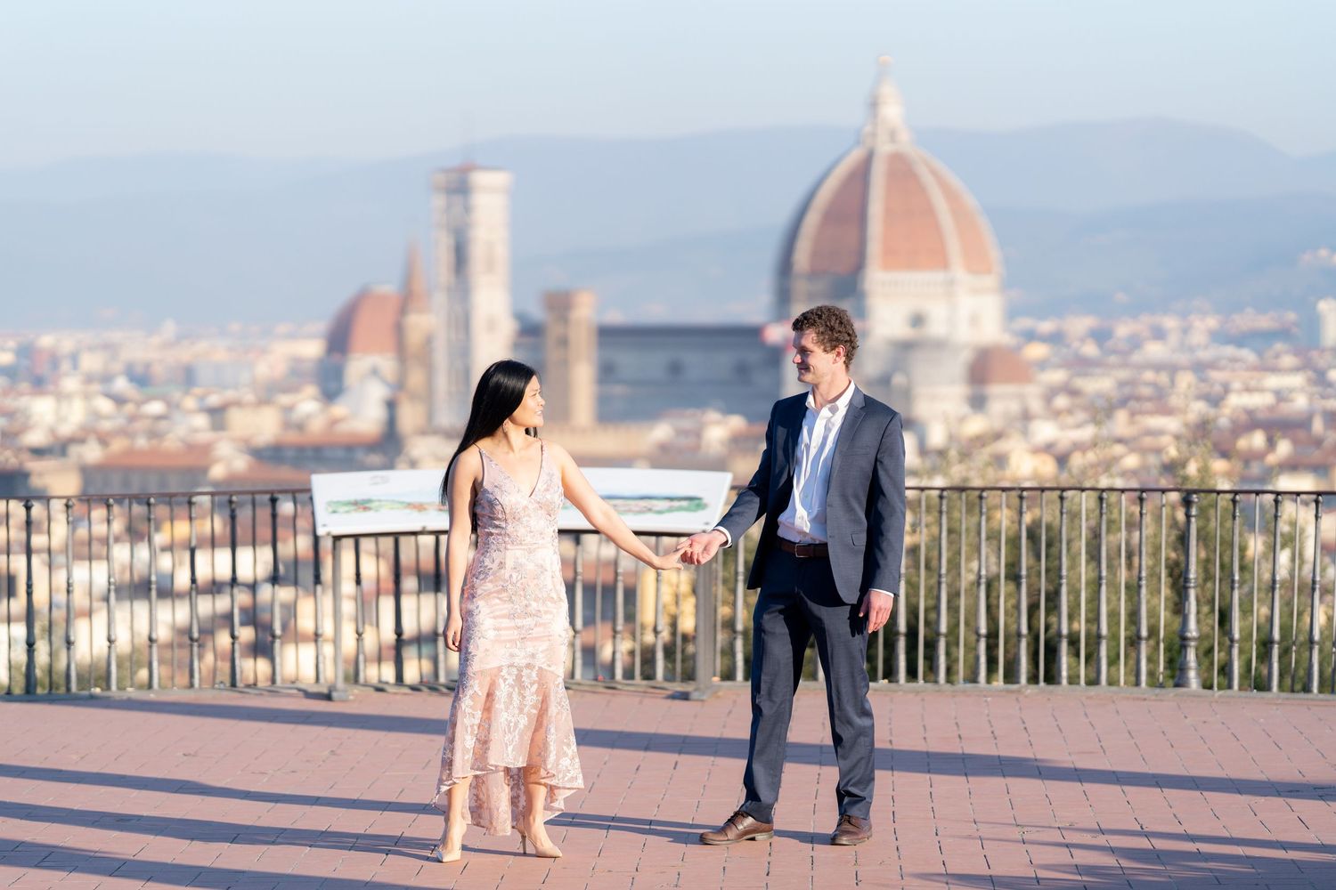 Romantic couple enjoys scenic views of Florence, Italy from Piazzale Michelangelo during golden hour.