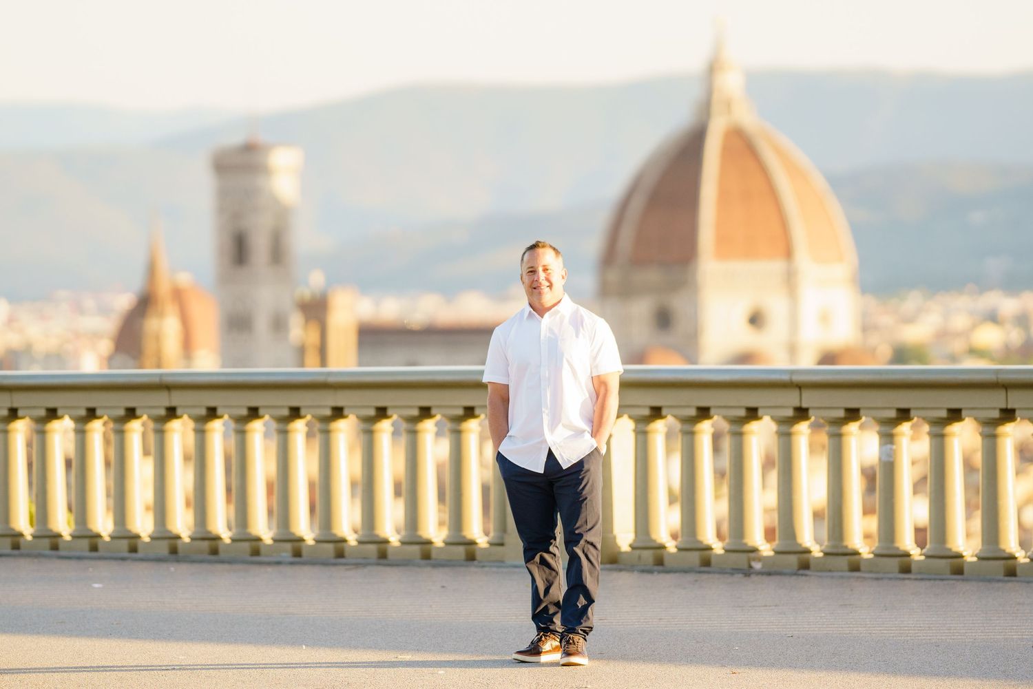 View of Florence cityscape with the iconic Duomo cathedral dome visible from a scenic terrace overlook.
