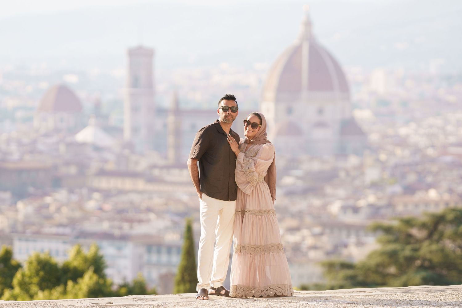 Couple posing together with Florence skyline and Cathedral of Santa Maria del Fiore in background, Italy.