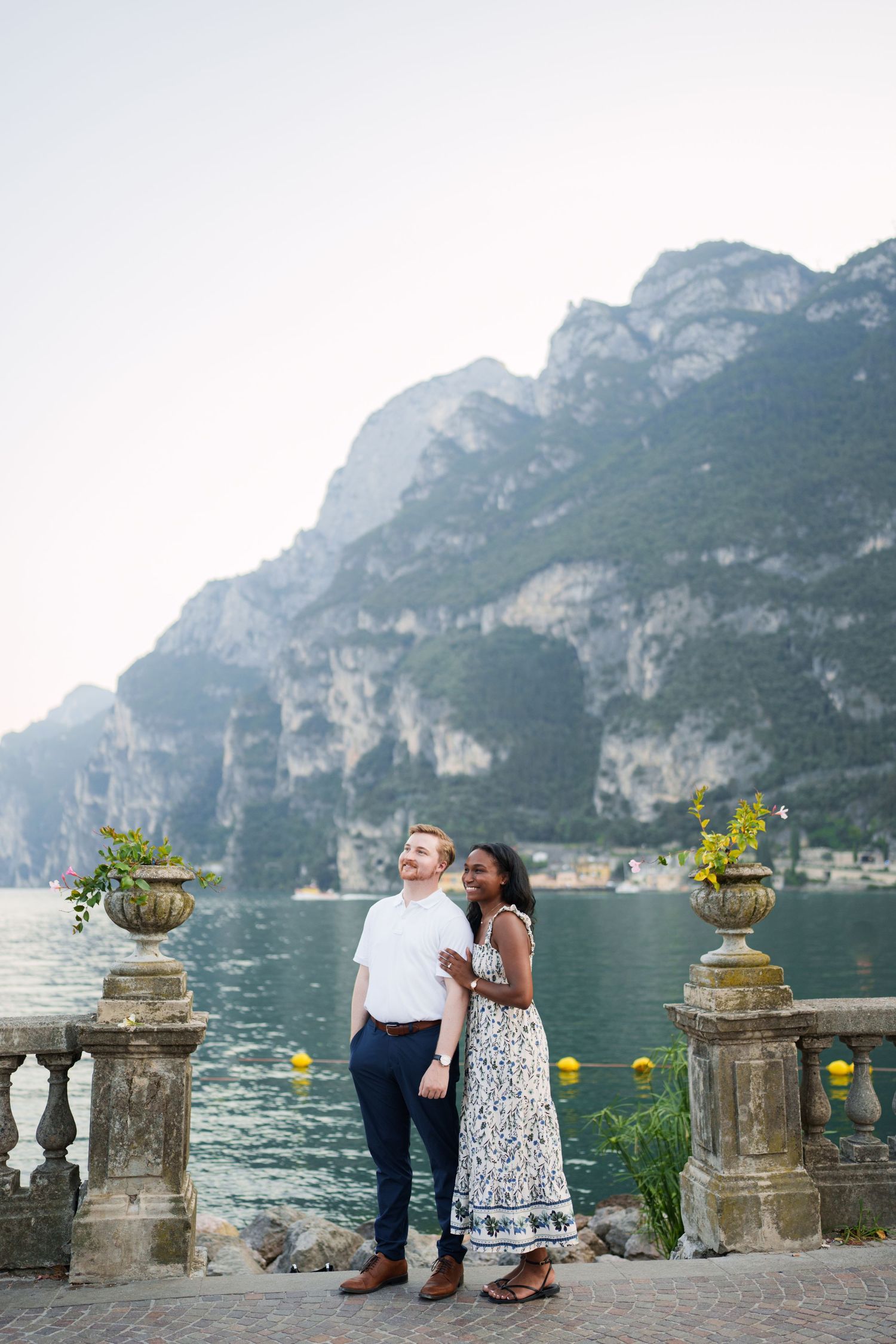 Engaged couple embracing beside Lake Garda during their Riva del Garda proposal session