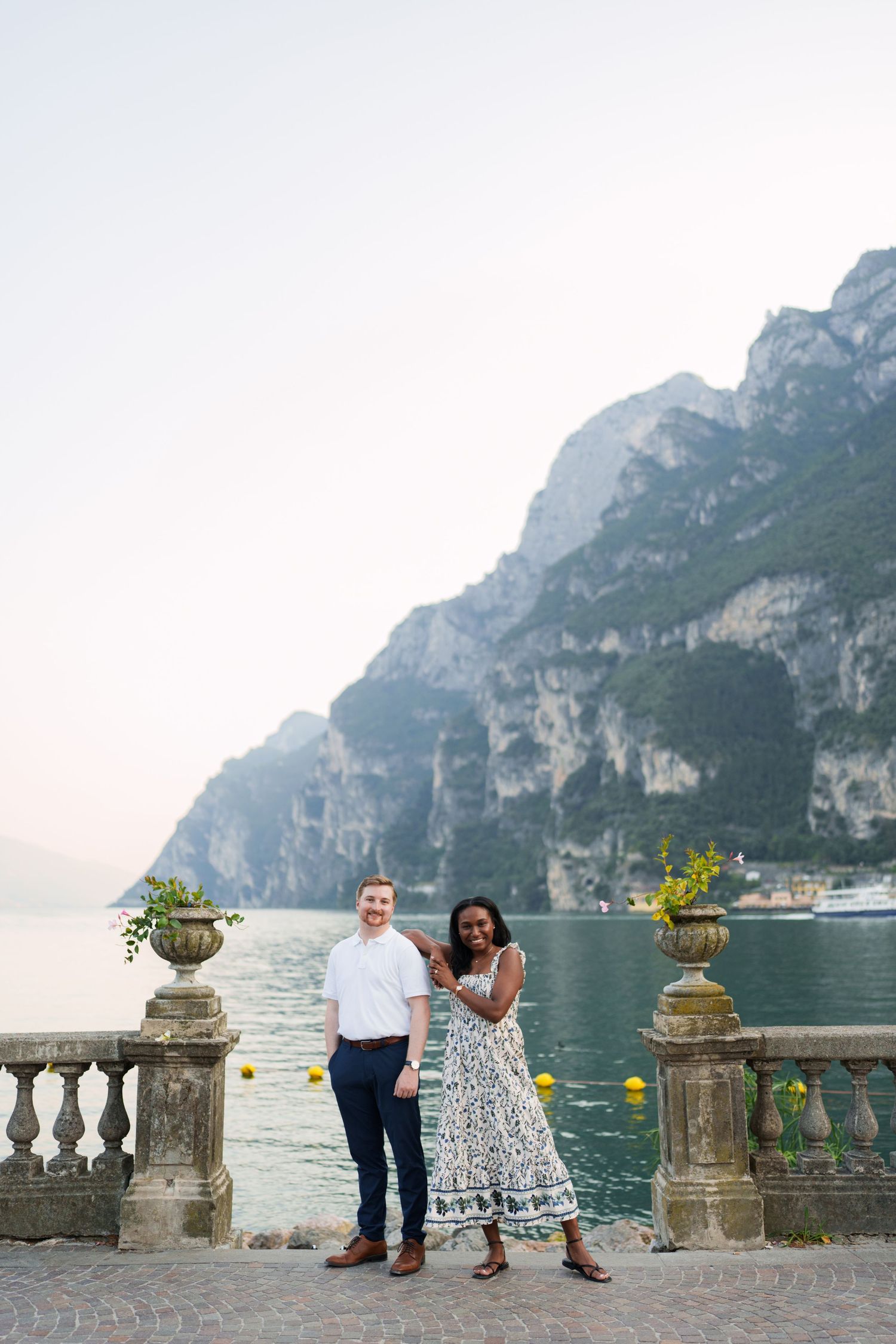 Engaged couple embracing beside Lake Garda during their Riva del Garda proposal session