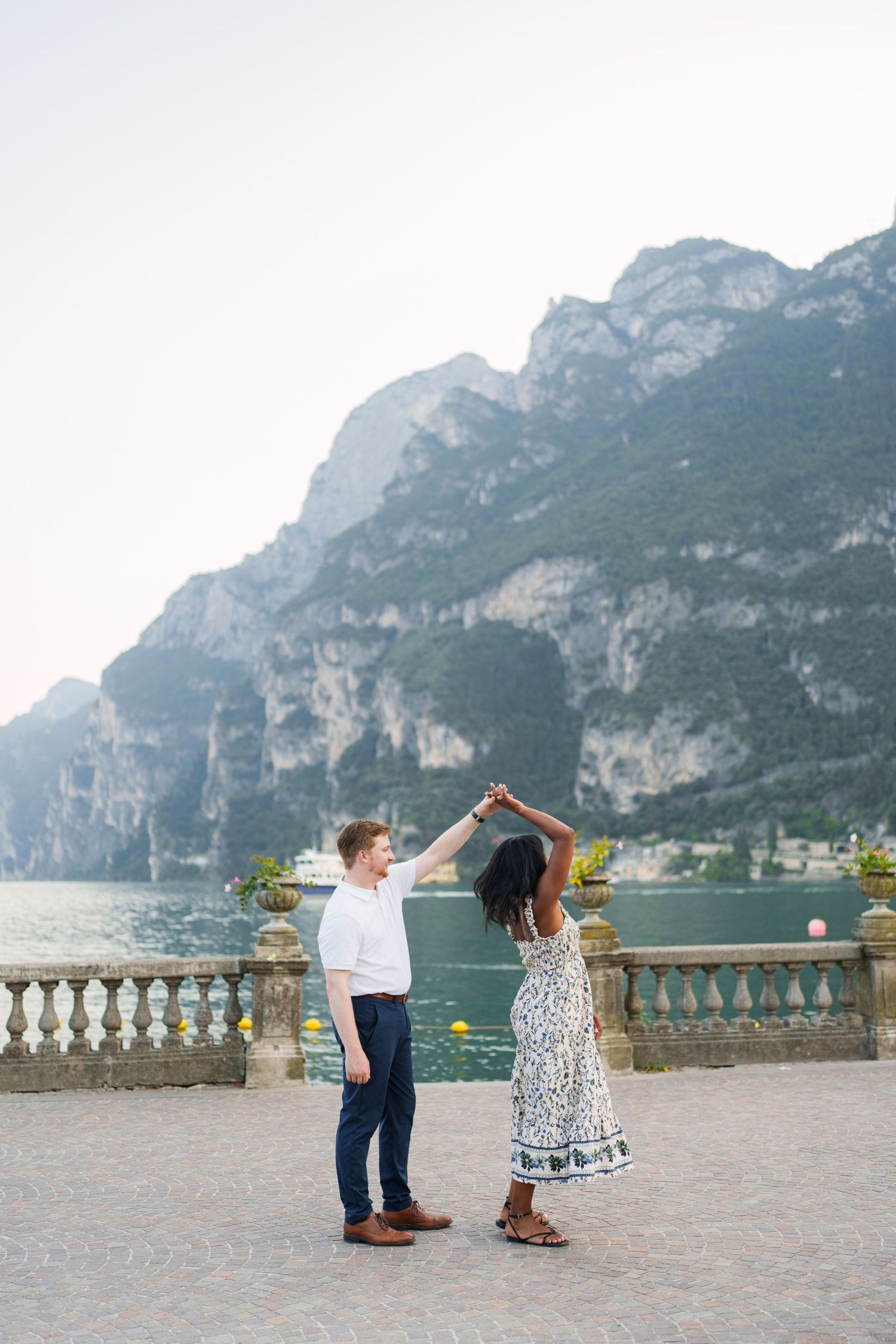 Engaged couple embracing beside Lake Garda during their Riva del Garda proposal session
