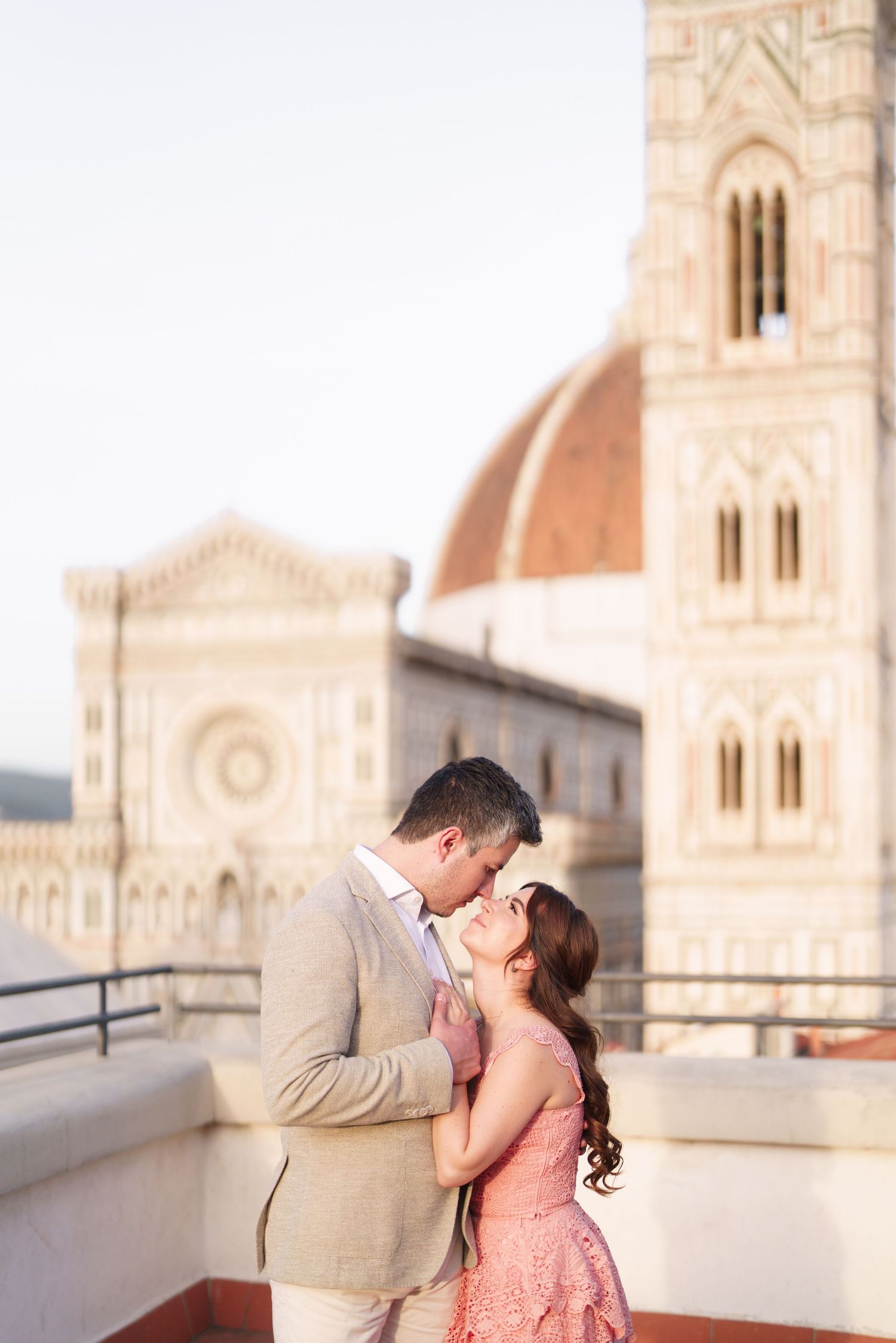 A romantic couple shares tender moments in front of the Florence Cathedral in Italy during sunset.