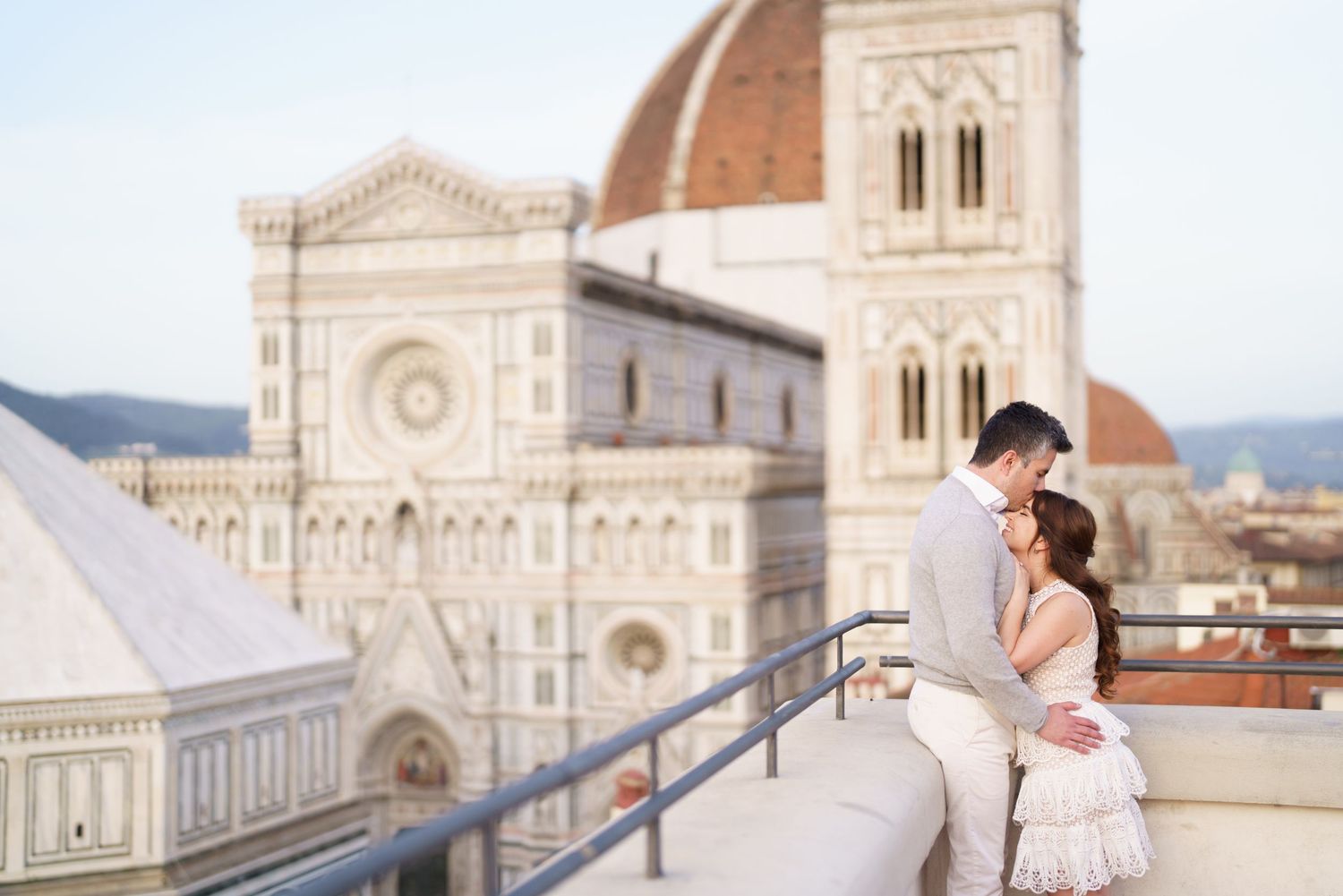 A couple stands on a terrace overlooking the historic Florence Cathedral and Duomo in Italy.