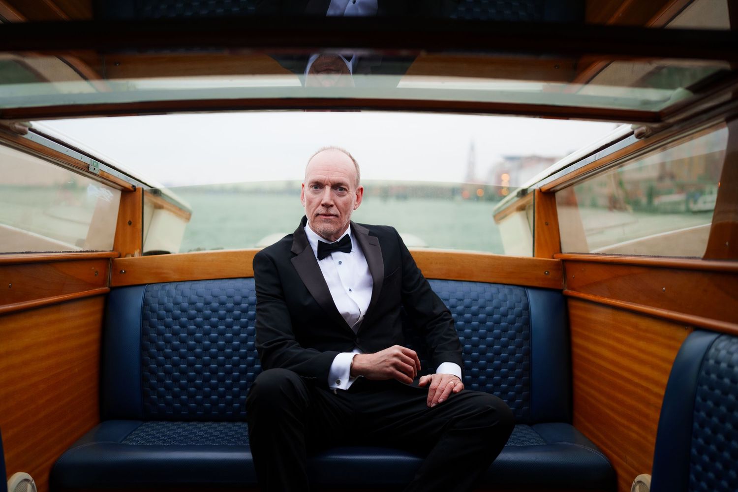 A series of interior shots of a luxury wooden boat cabin with blue upholstered seating and elegant details.