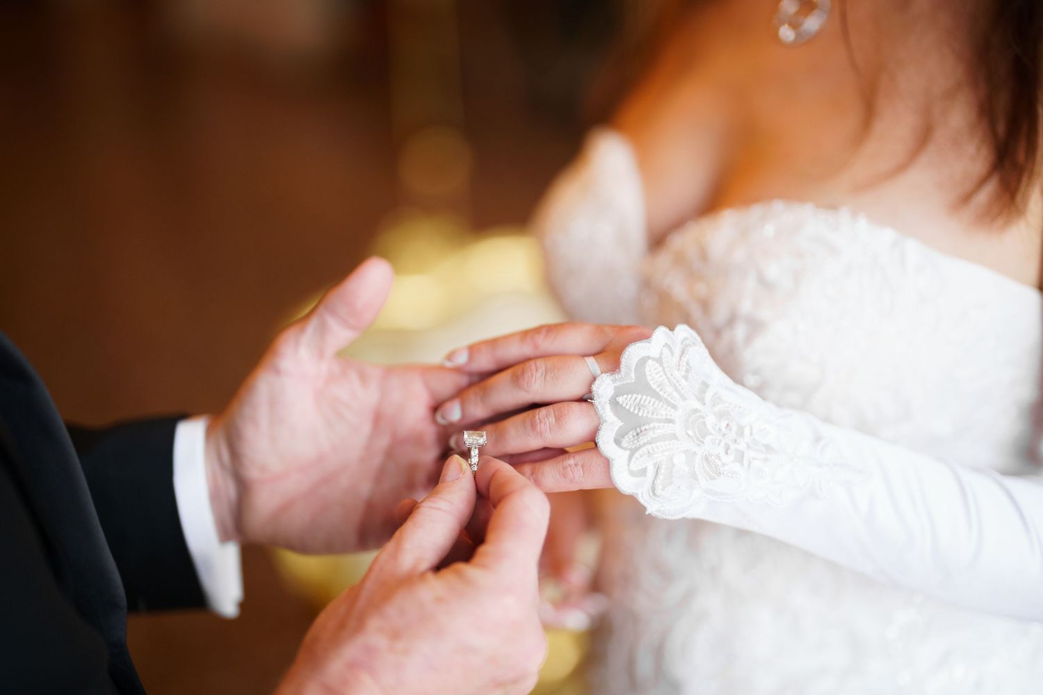 Close-up of hands exchanging wedding rings during a traditional ceremony.