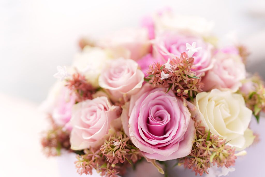 Delicate arrangement of pink and white roses with soft focus creating a romantic backdrop.