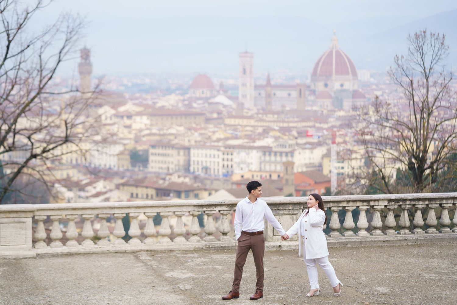 Couple enjoying panoramic view of Florence from Piazzale Michelangelo viewpoint.