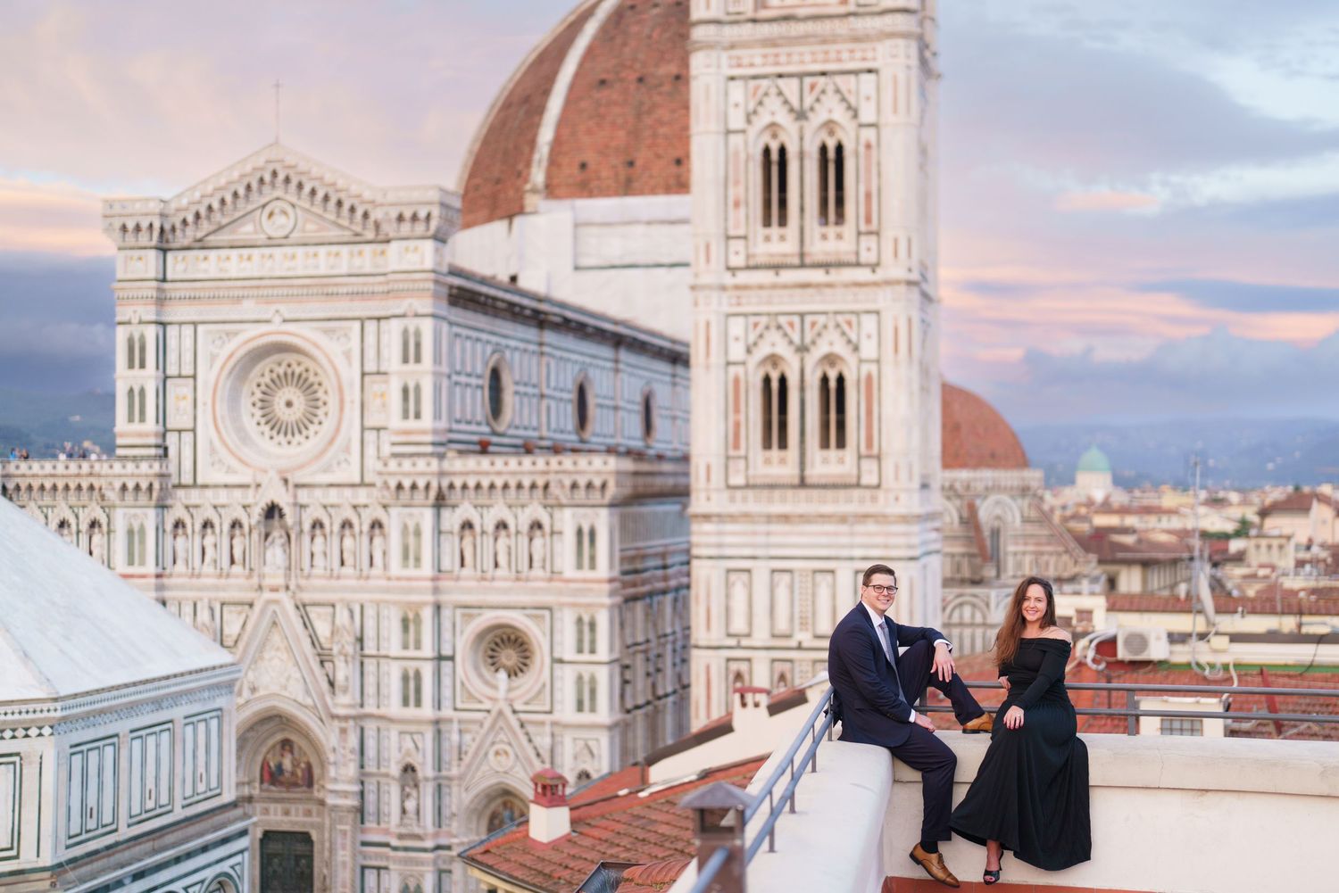 Historic Florence Cathedral and Duomo with its iconic red dome rises majestically against a pink sunset sky in Italy.