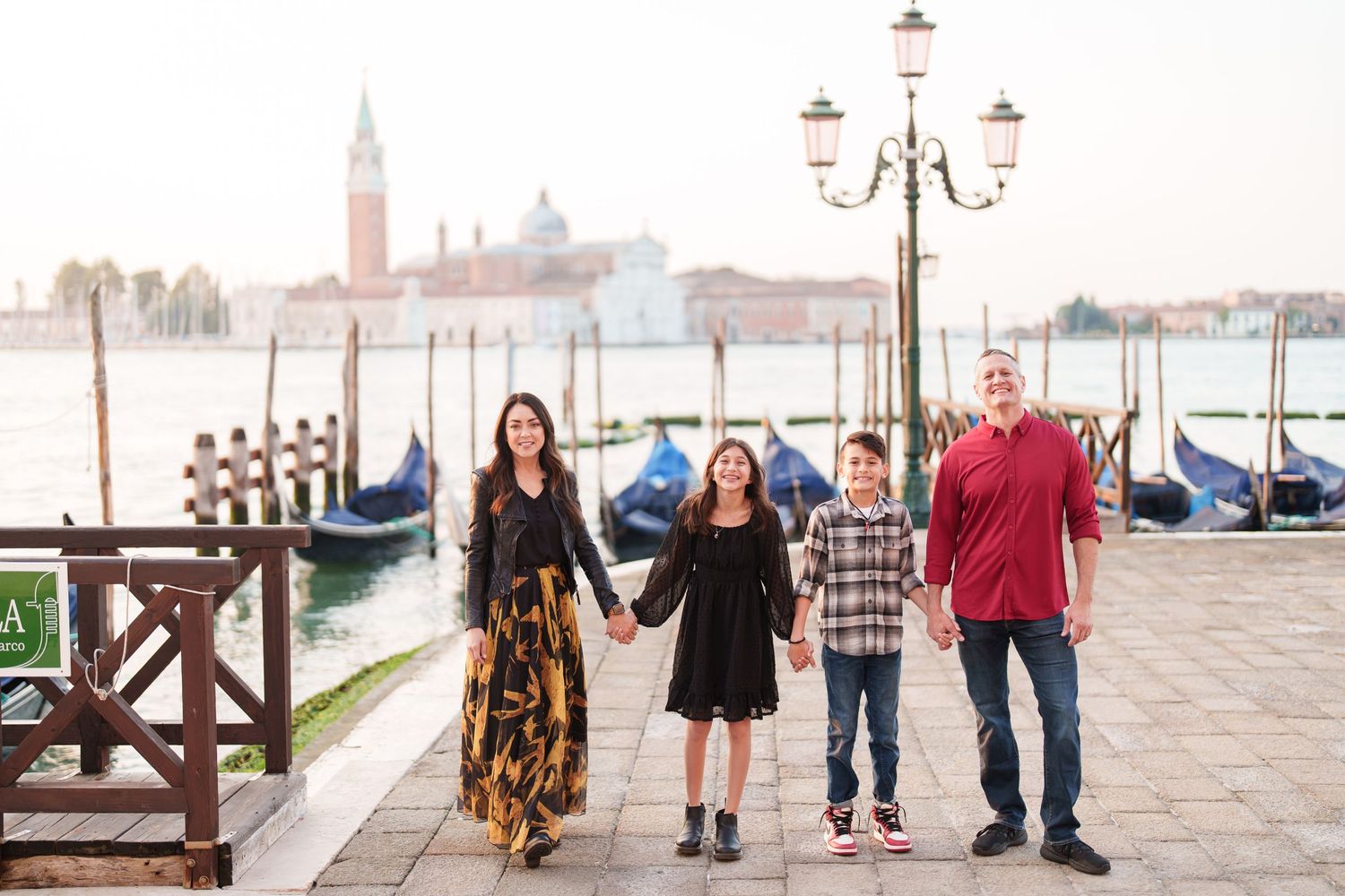 Scenic waterfront view of Venice with gondolas and historic buildings along the canal at sunset.