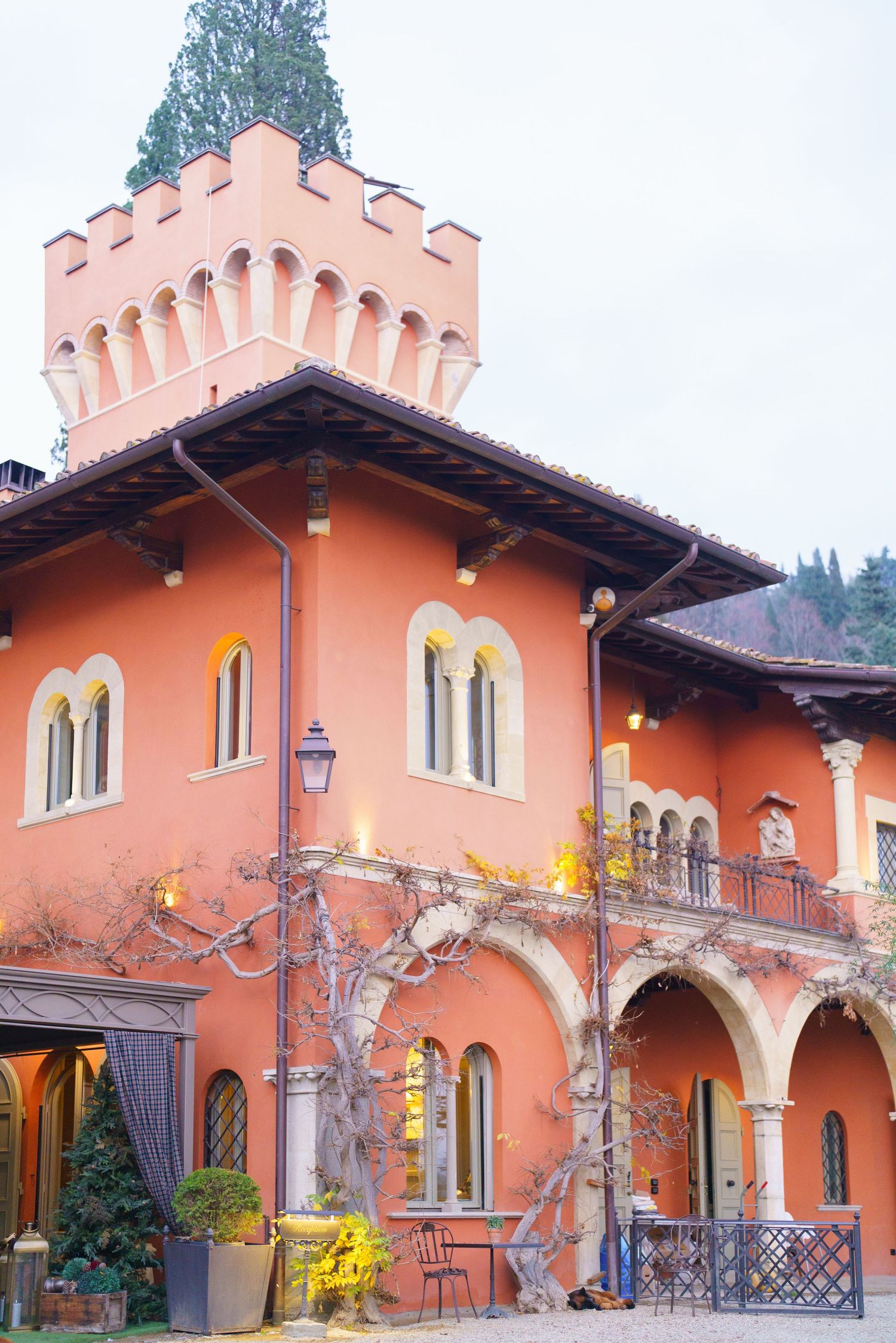 Spanish-style villa with peach-colored walls and ornate architectural details under blue sky.