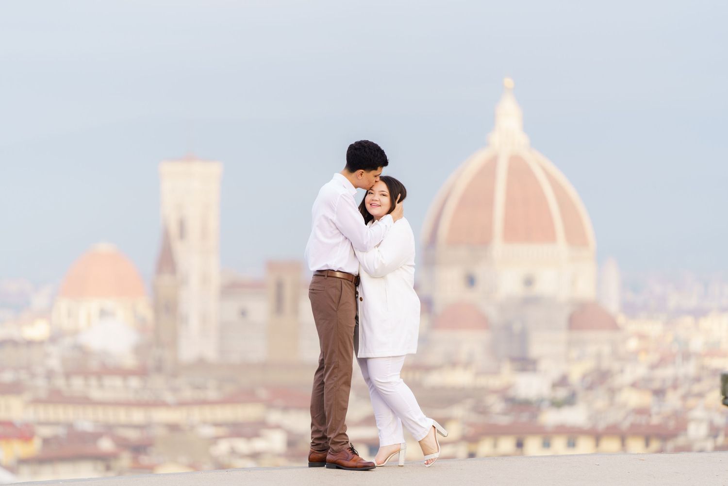 Romantic embrace against Florence skyline with iconic Duomo cathedral dome.