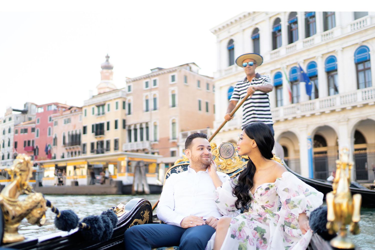 Scenic view of Venice's Grand Canal with gondolas, historic buildings, and tourists enjoying the waterfront atmosphere.