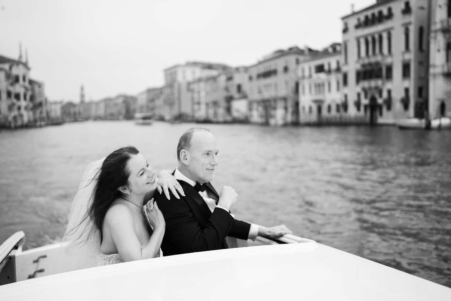 A series of black and white photos showing romantic moments along the Venice canals with gondolas and historic buildings.