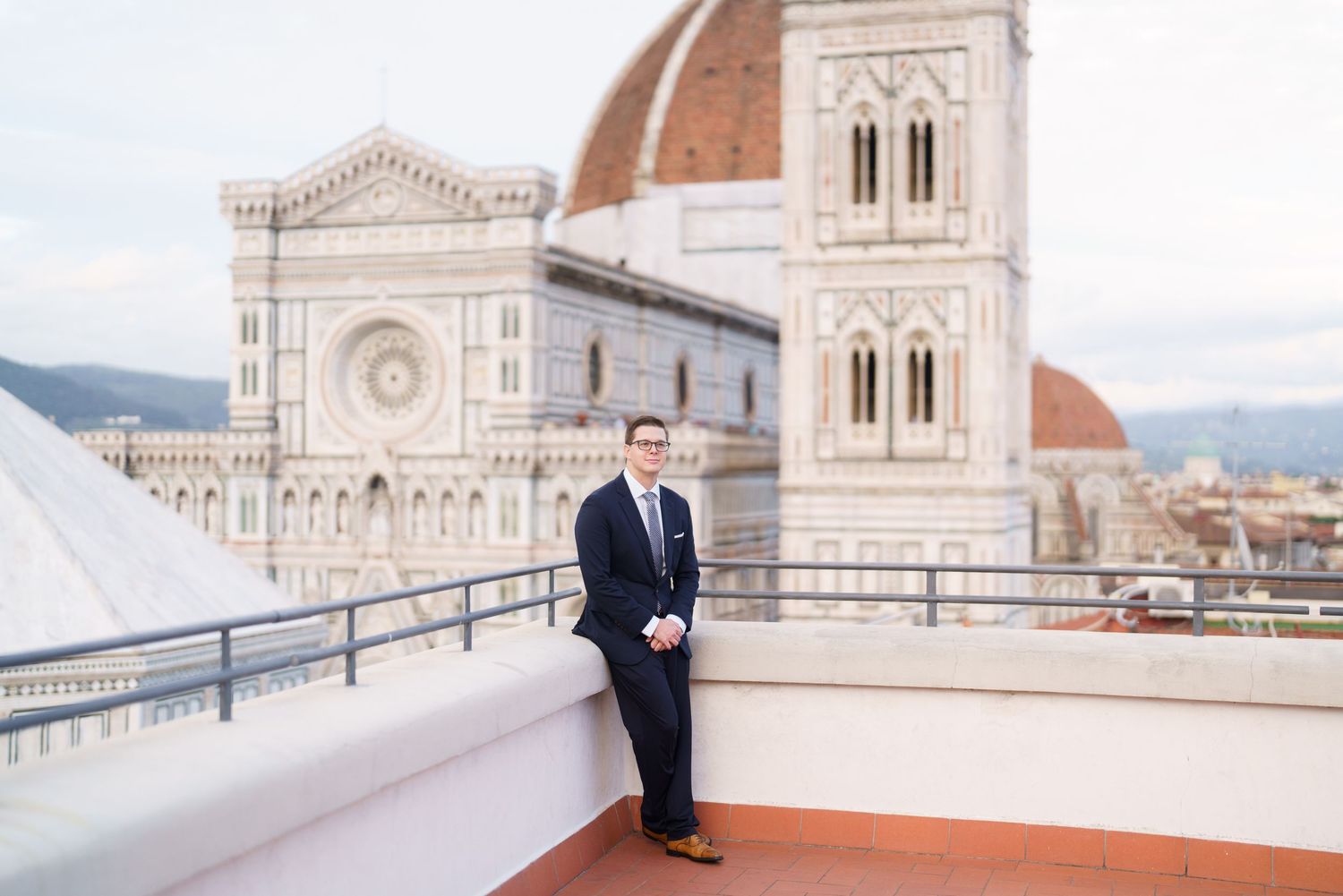 View of Florence Cathedral's iconic dome and facade from a rooftop terrace in Italy.