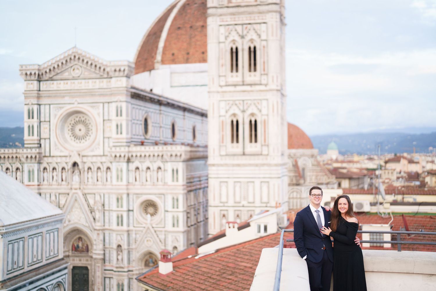 View of the iconic Florence Cathedral with its grand Renaissance dome and ornate marble facade against a bright blue sky.