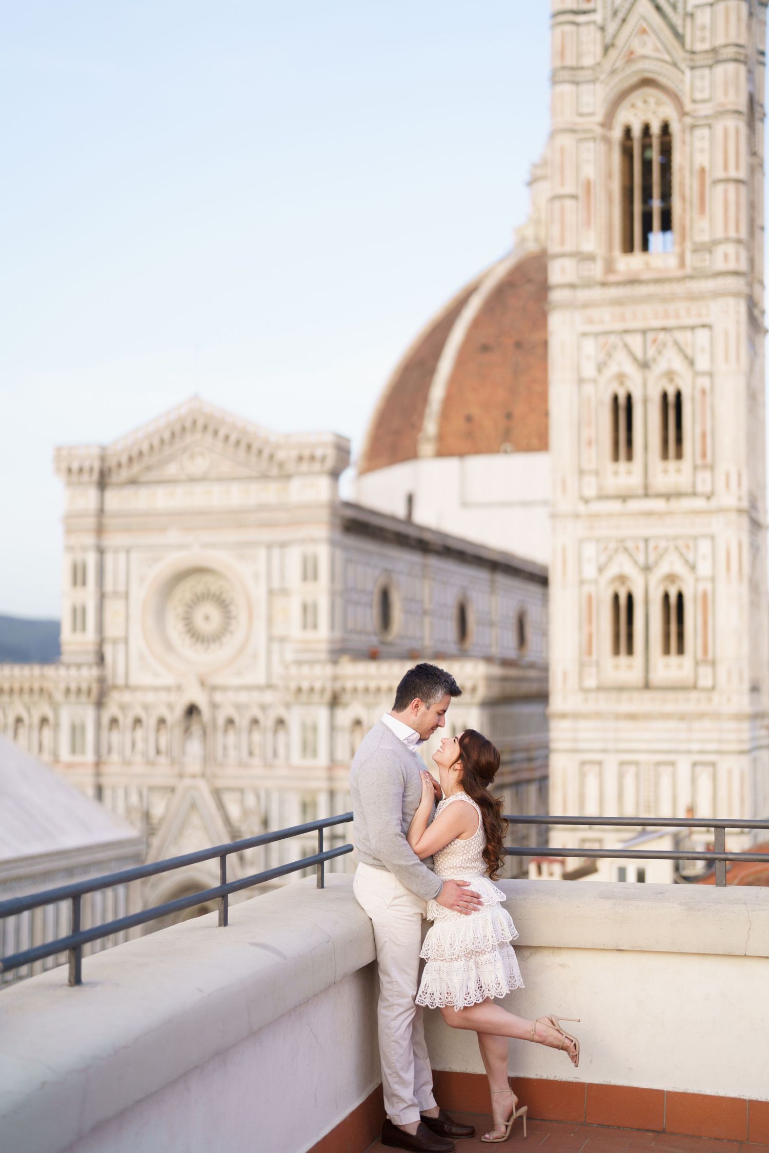Romantic couple embracing against the backdrop of Florence Cathedral's iconic marble facade and dome in Italy.