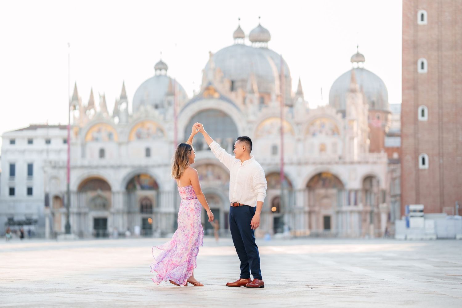 Couple dancing in St. Mark's Square, Venice, with the iconic Basilica di San Marco in the background.