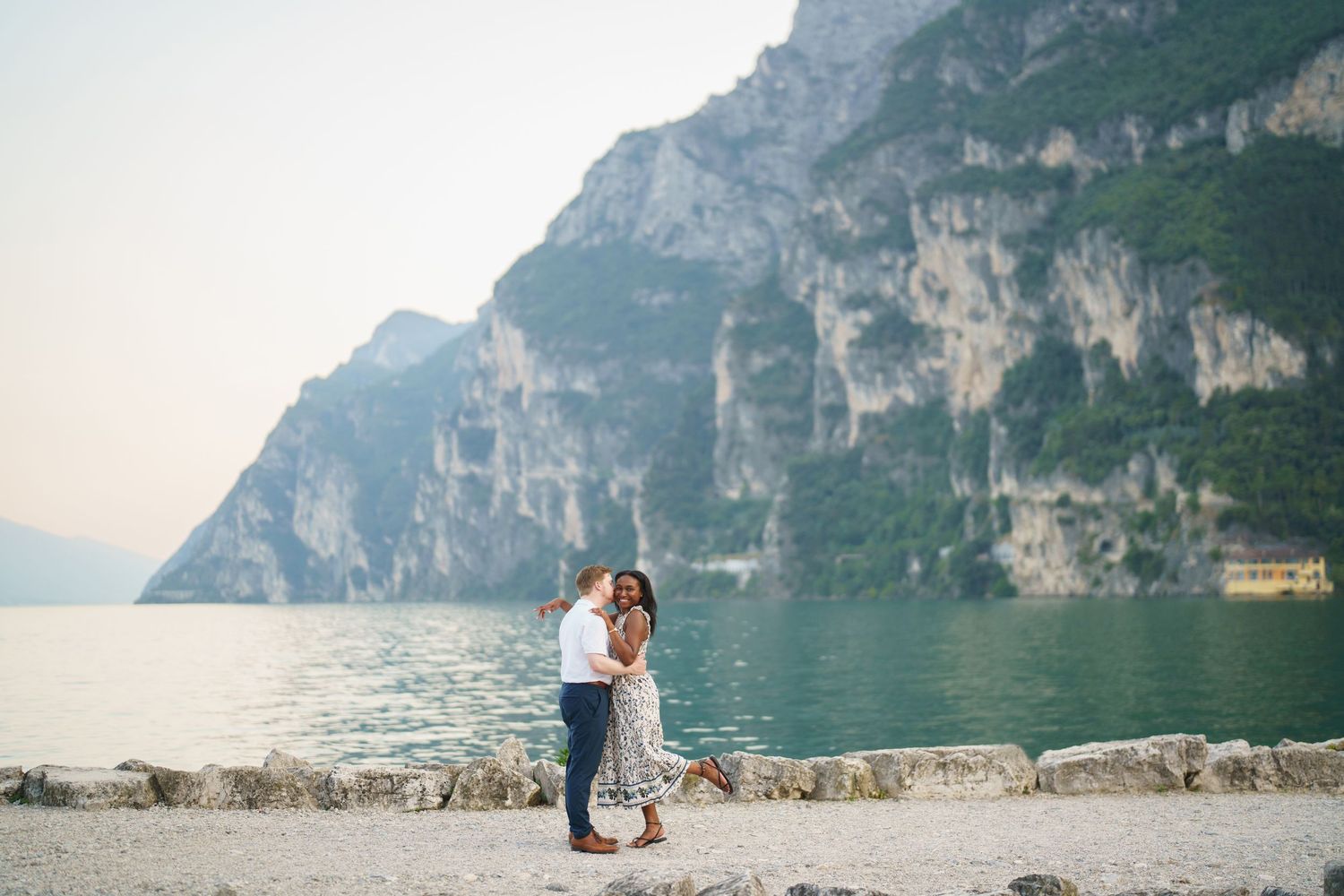 Couple portrait by Lake Garda surrounded by mountains in Riva del Garda, Italy