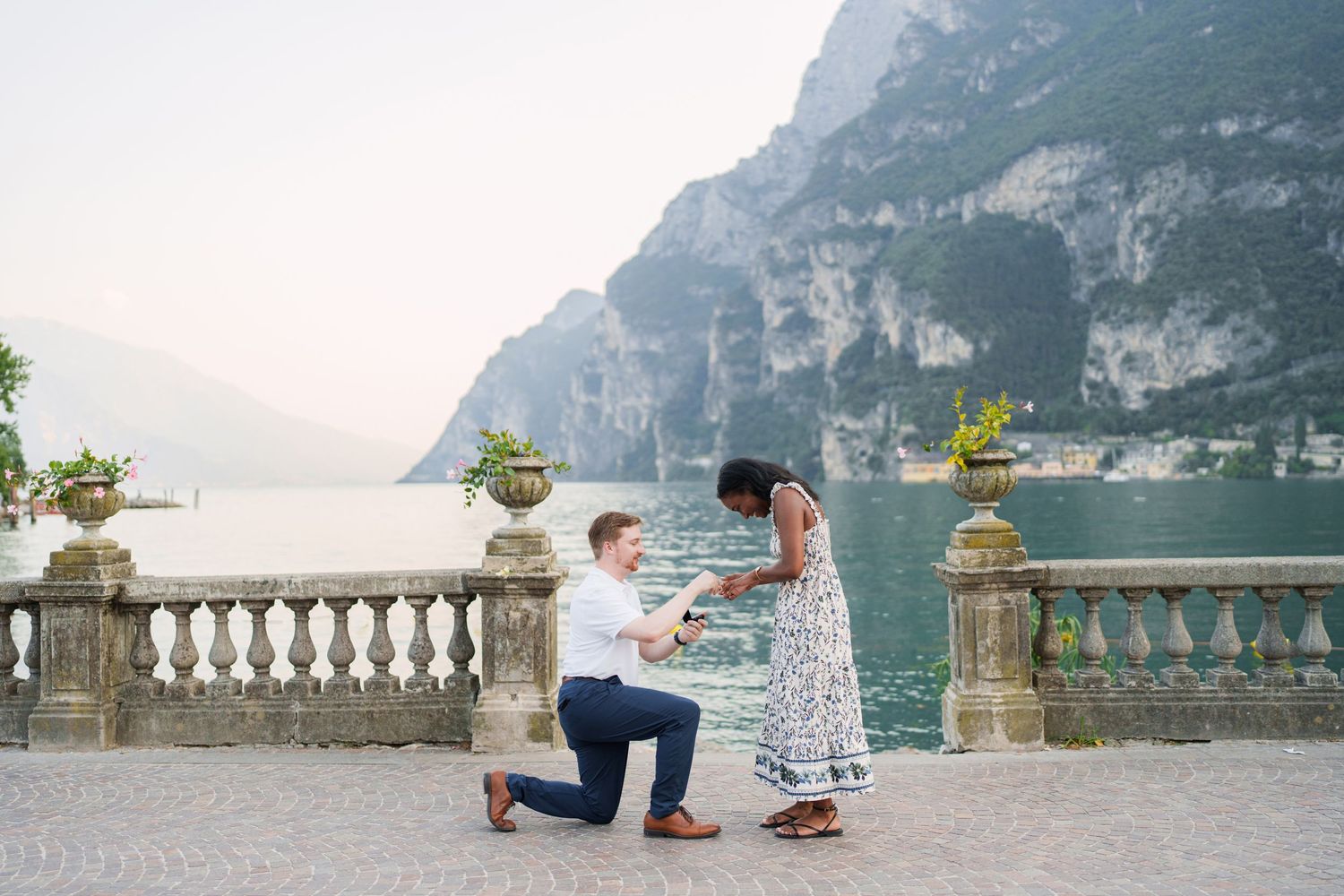 Engaged couple embracing beside Lake Garda during their Riva del Garda proposal session