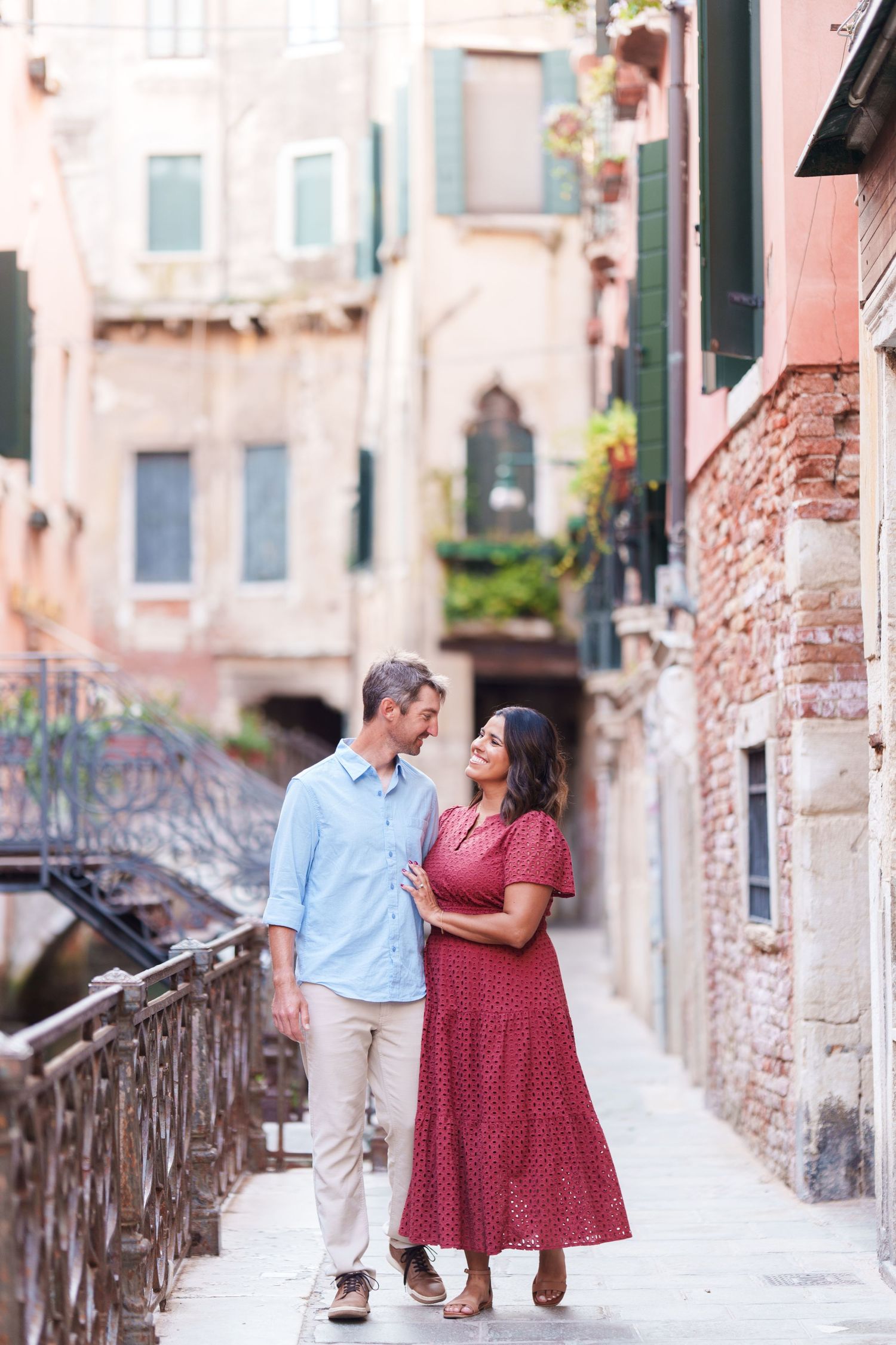 Romantic couple embracing on a charming Venice canal street, surrounded by historic Italian architecture.