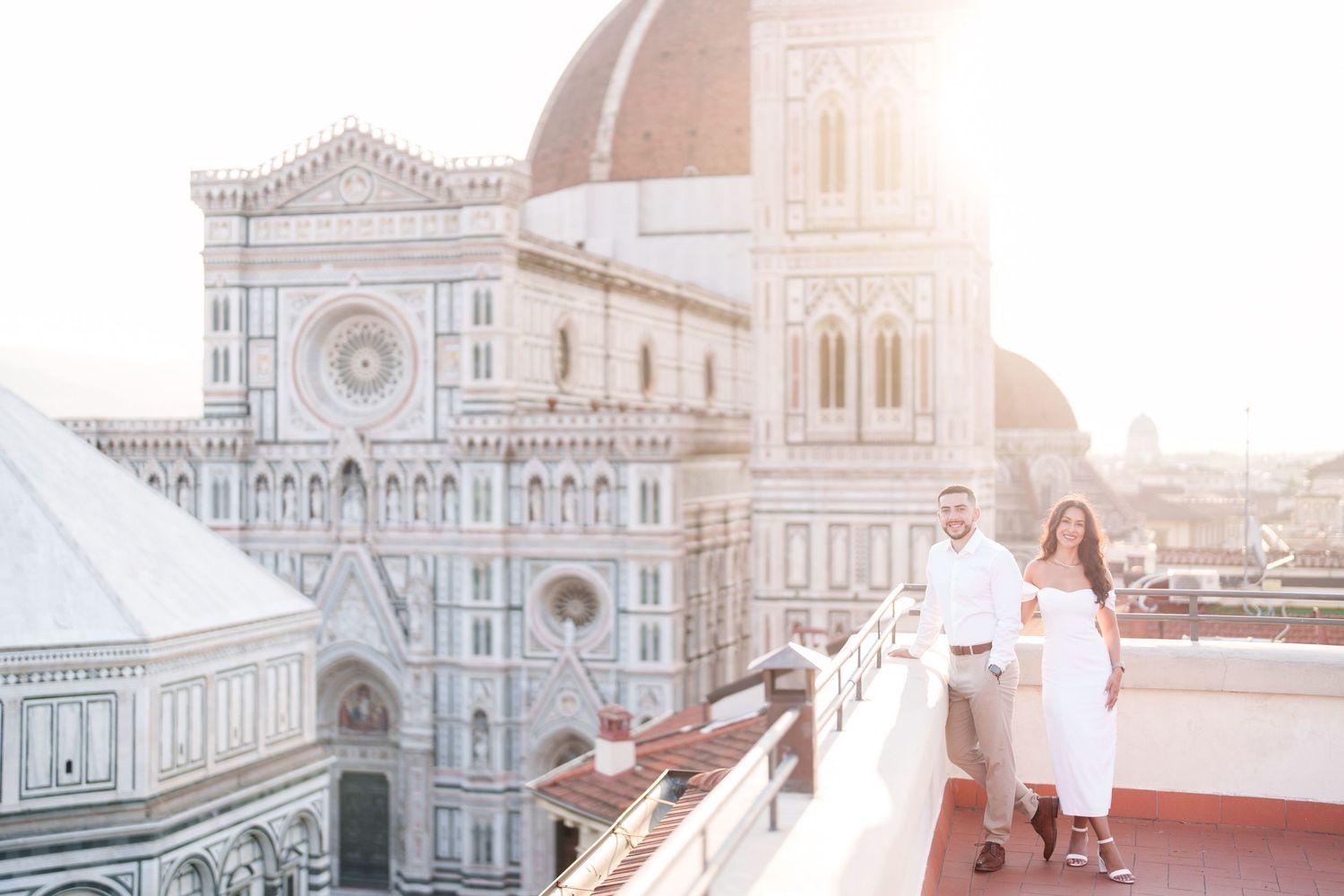 A romantic couple shares a tender moment against the backdrop of Florence's iconic Duomo cathedral at sunset.