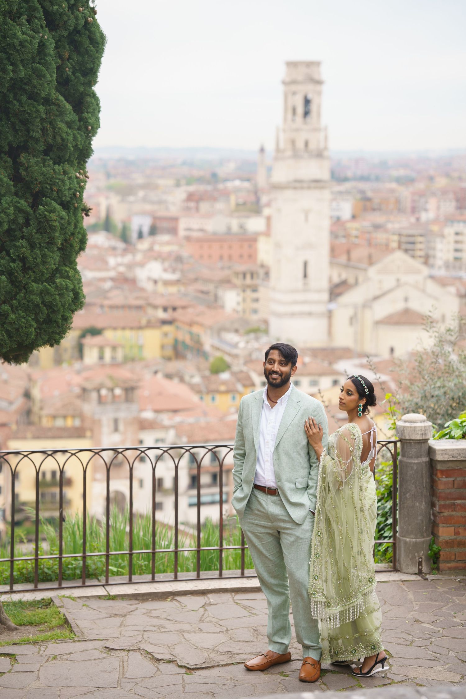 A couple shares a romantic moment overlooking the scenic terracotta rooftops and bell tower of Florence, Italy.
