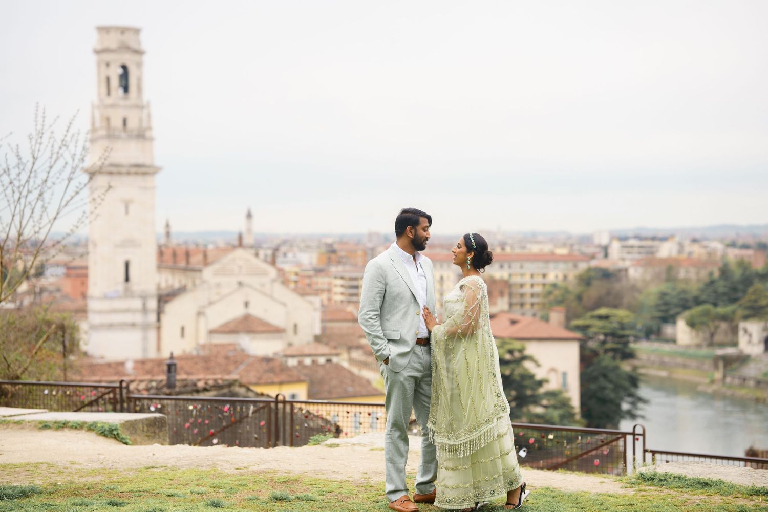 Romantic couple enjoying a scenic view of Florence, Italy from a hilltop overlook with historic architecture in background.