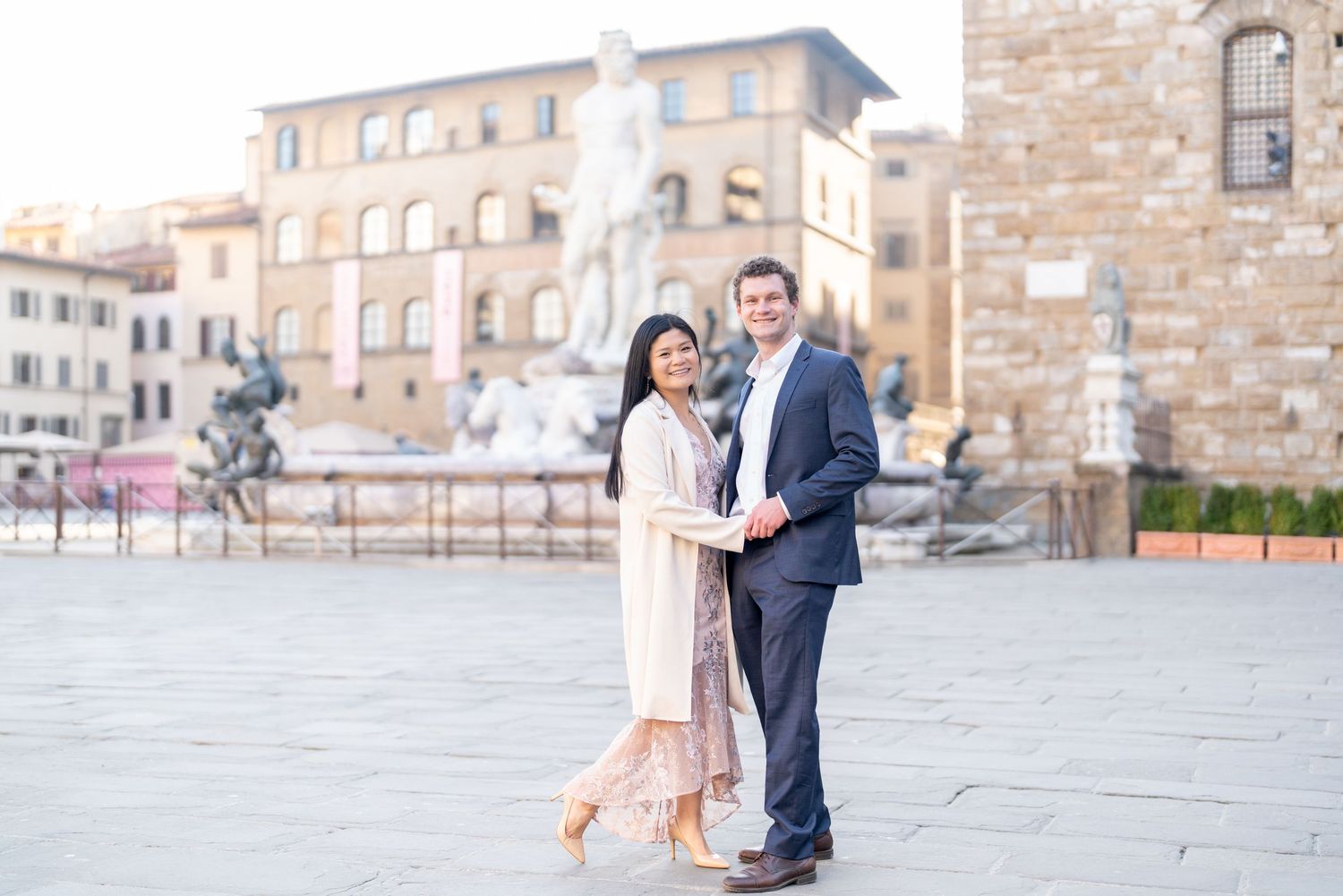 A couple shares romantic moments in front of a historic stone building during a photo session.