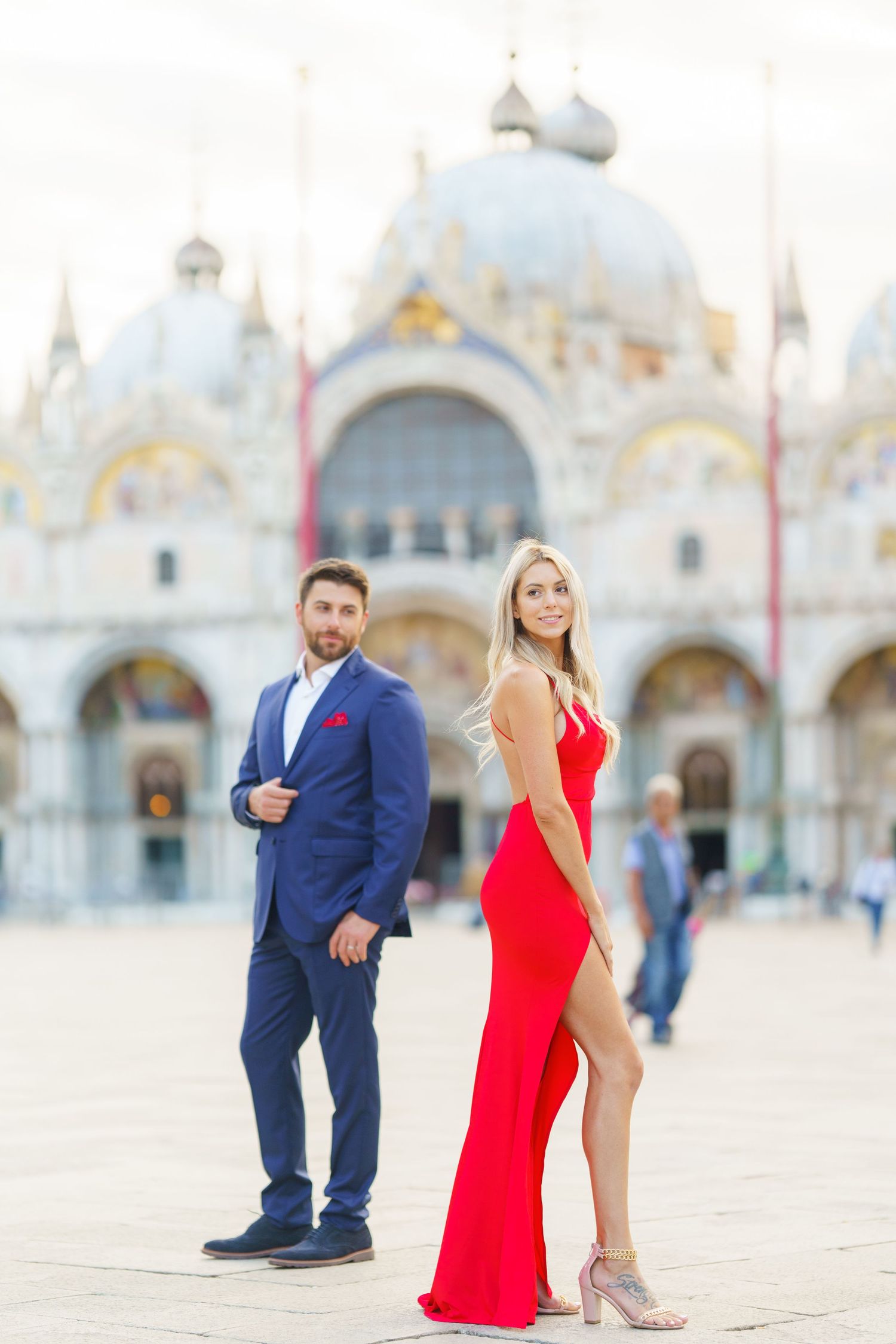 A couple poses for photos in formal attire at Saint Mark's Square in Venice, Italy.