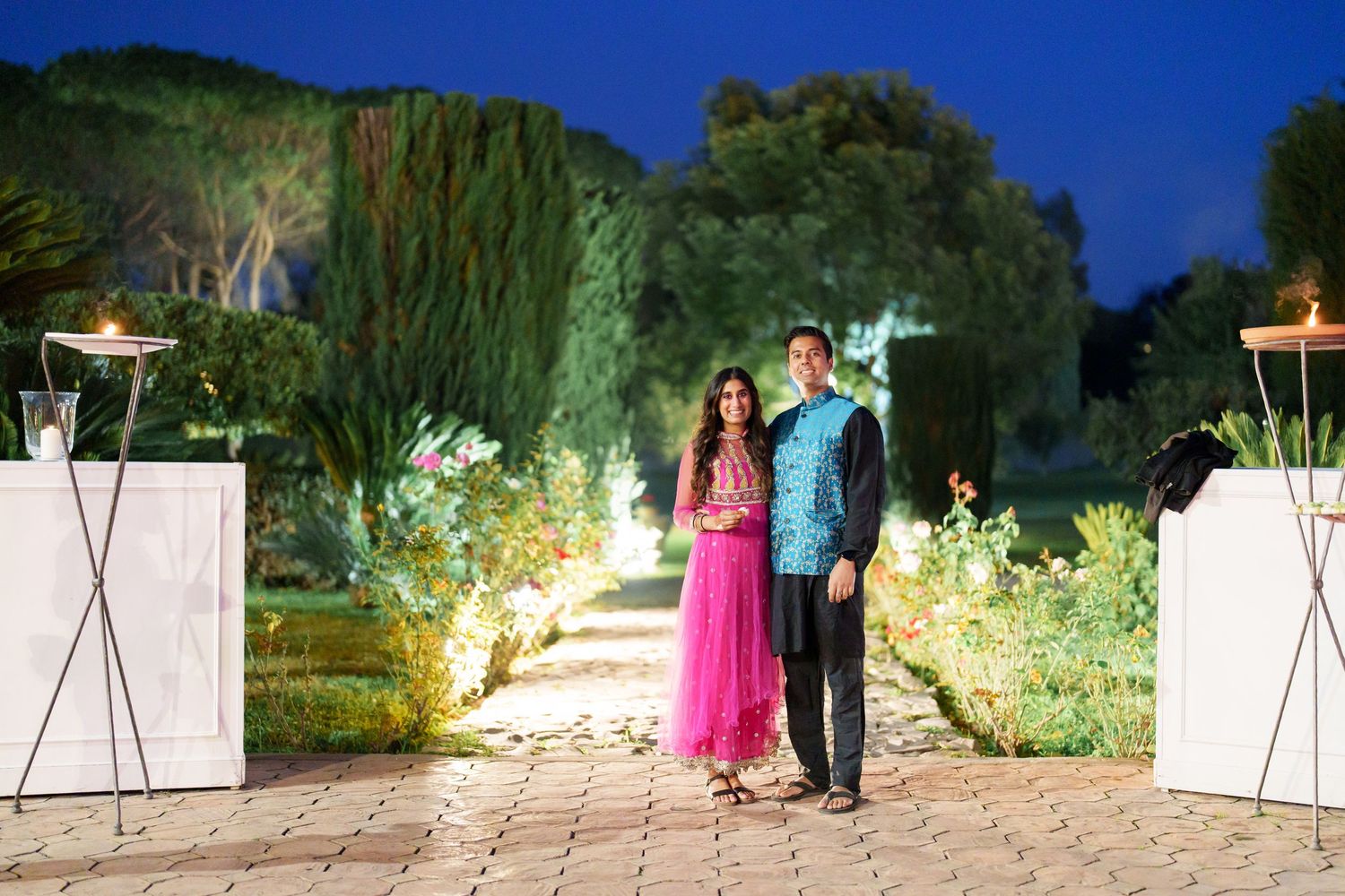 Outdoor evening event with string lights illuminating a garden pathway.