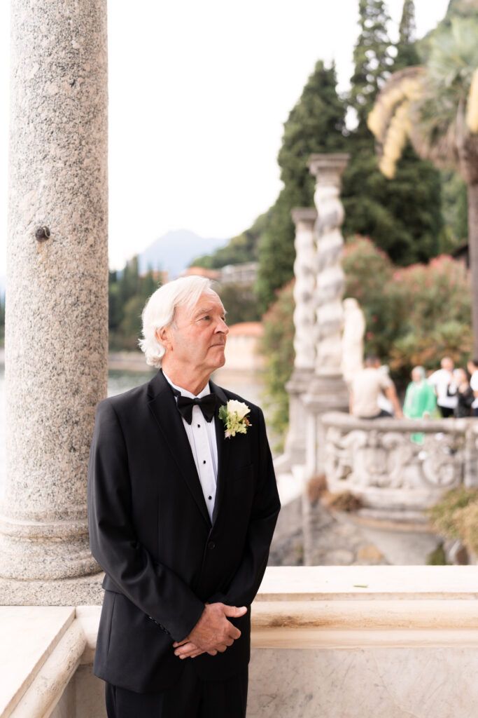 Formal attire photoshoot on an elegant Italian villa terrace with stone columns.