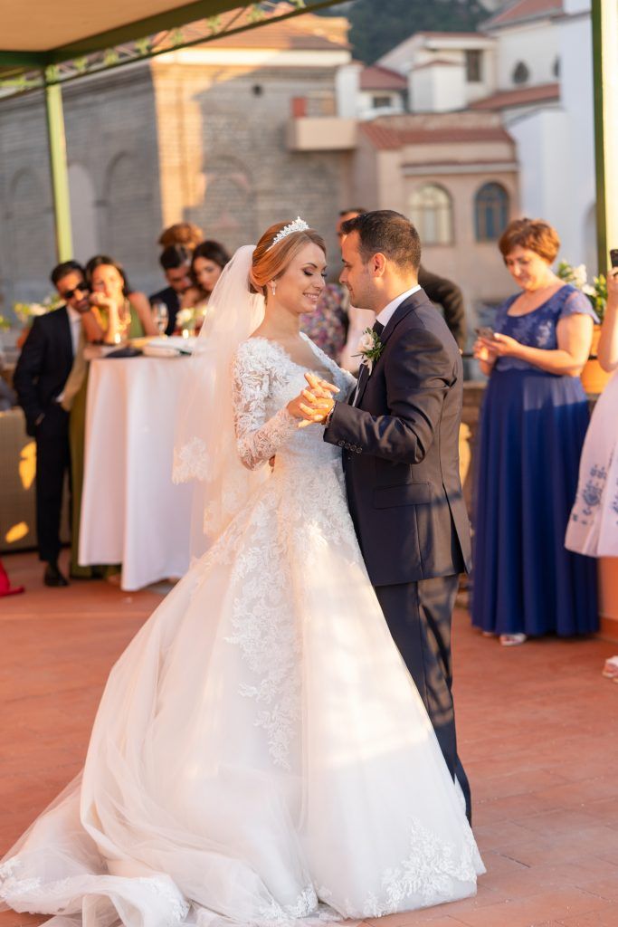 Wedding dance sequence on a terrace with guests watching in the background.