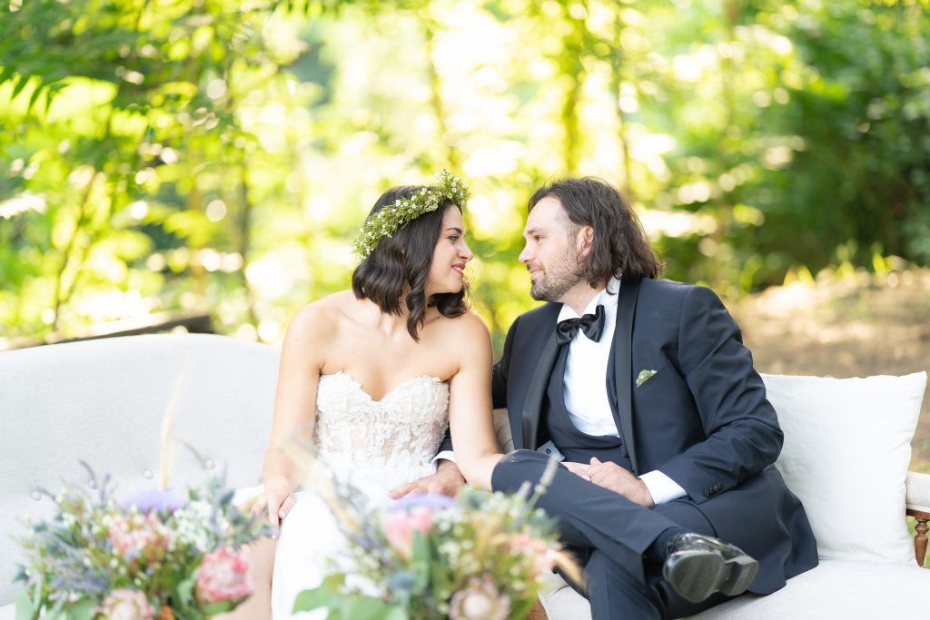 Intimate garden scene with formal attire and natural greenery backdrop.