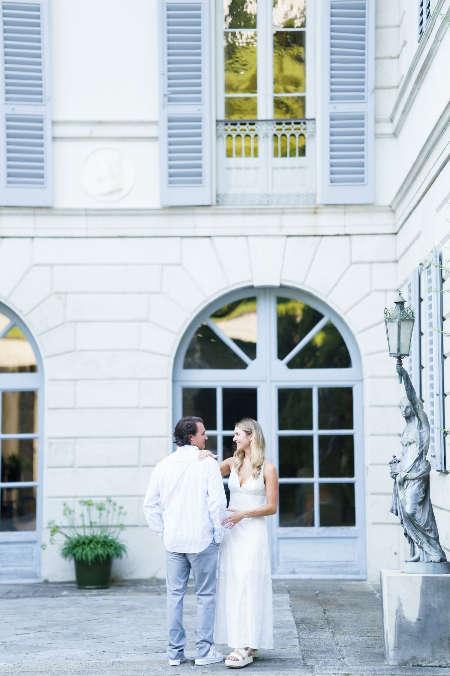 A romantic wedding photo sequence showing a couple in white and gray against a white mansion with blue shutters.