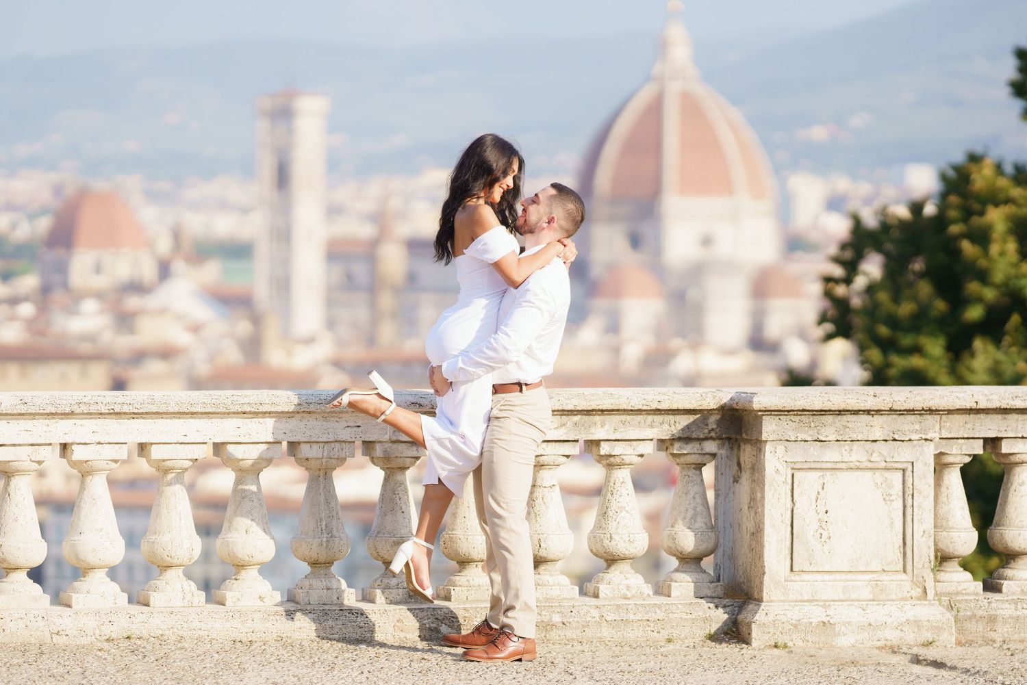 A romantic moment overlooking Florence, Italy with the iconic Duomo cathedral dome visible in the cityscape background.